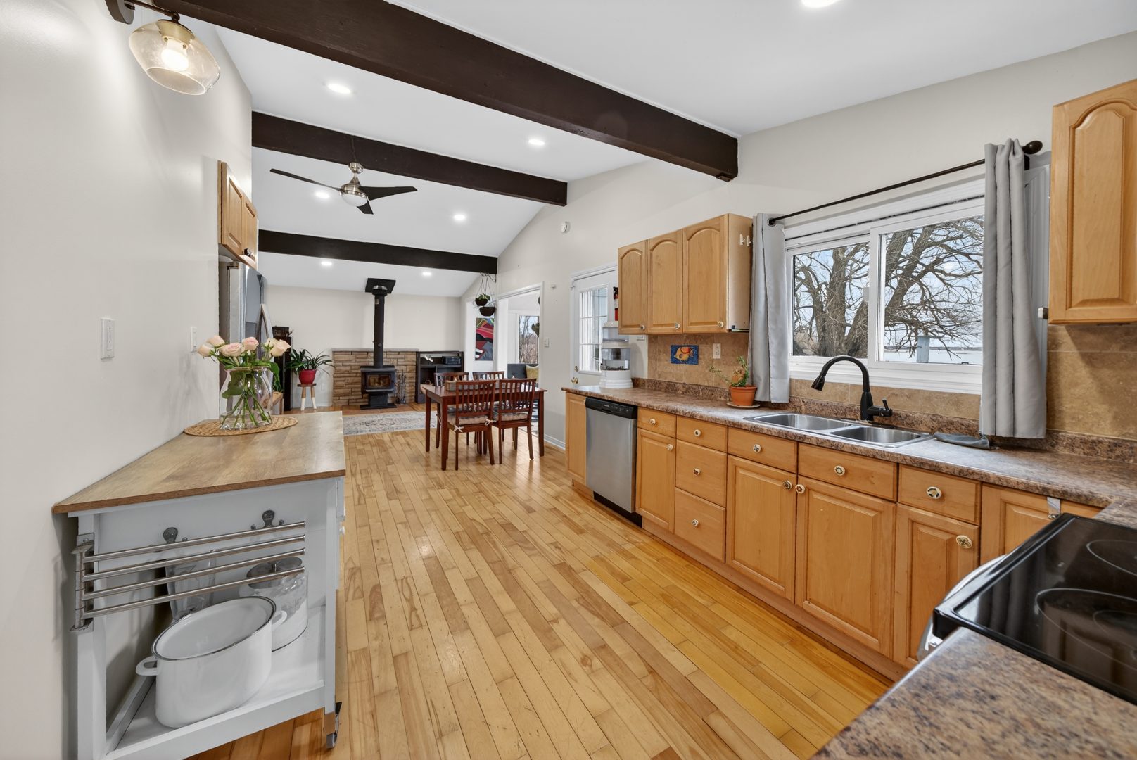 A kitchen with light wood paneling in a narrow room