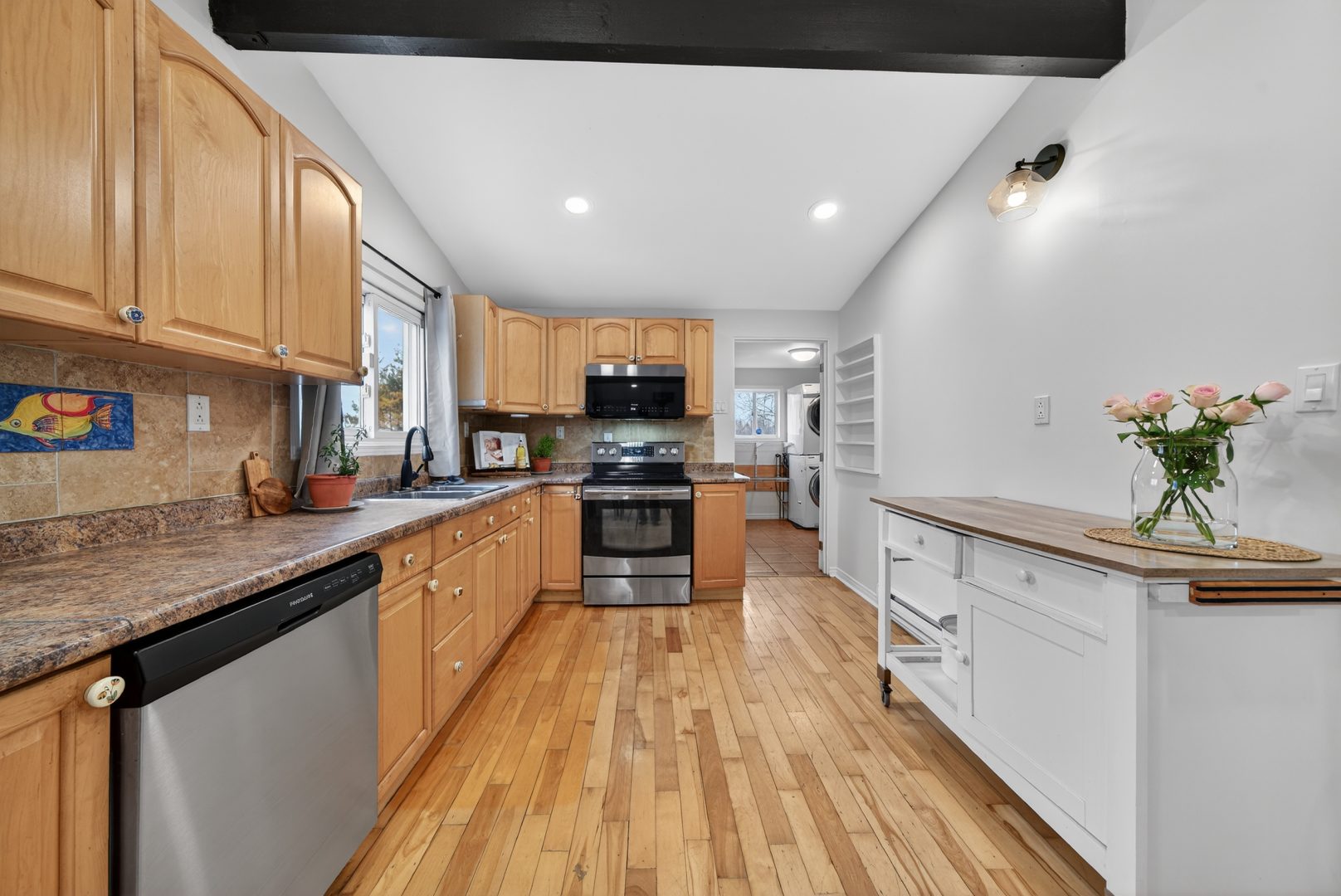 Wood cabinetry with stainless steel appliances in a white kitchen