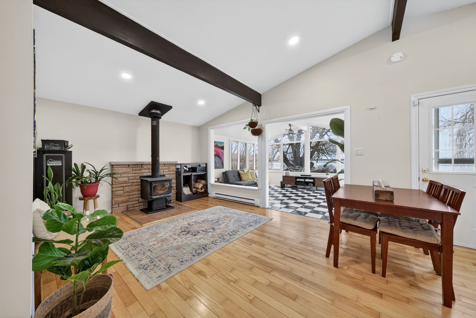 A white living area with wood flooring and a black wood stove