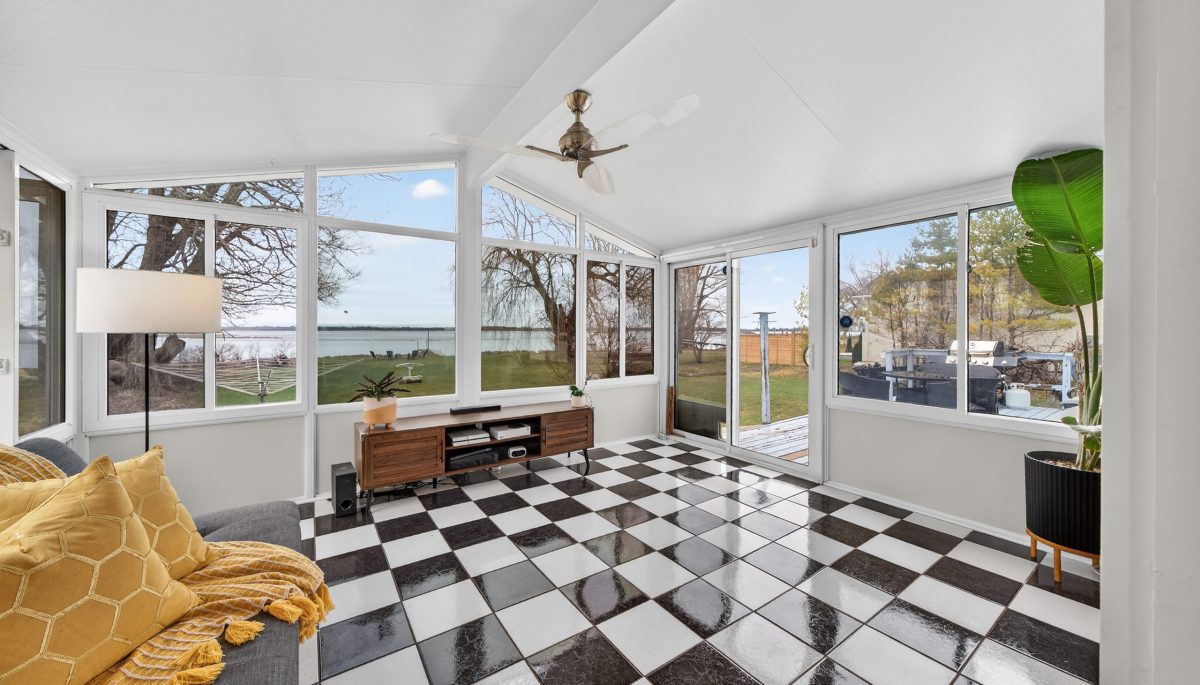 A white sun room with black-and-white checkered flooring and windows