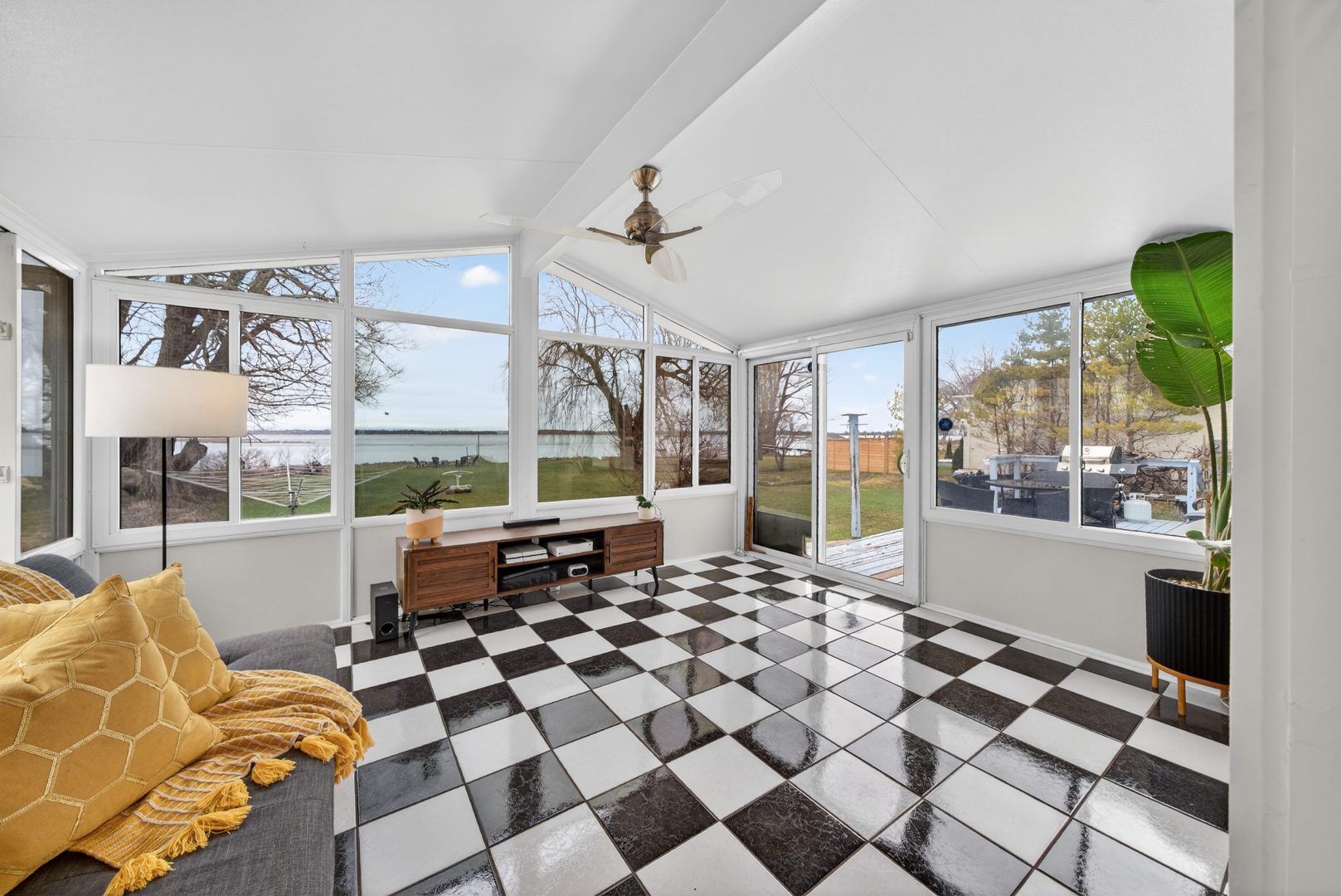 A white sun room with black-and-white checkered flooring and windows