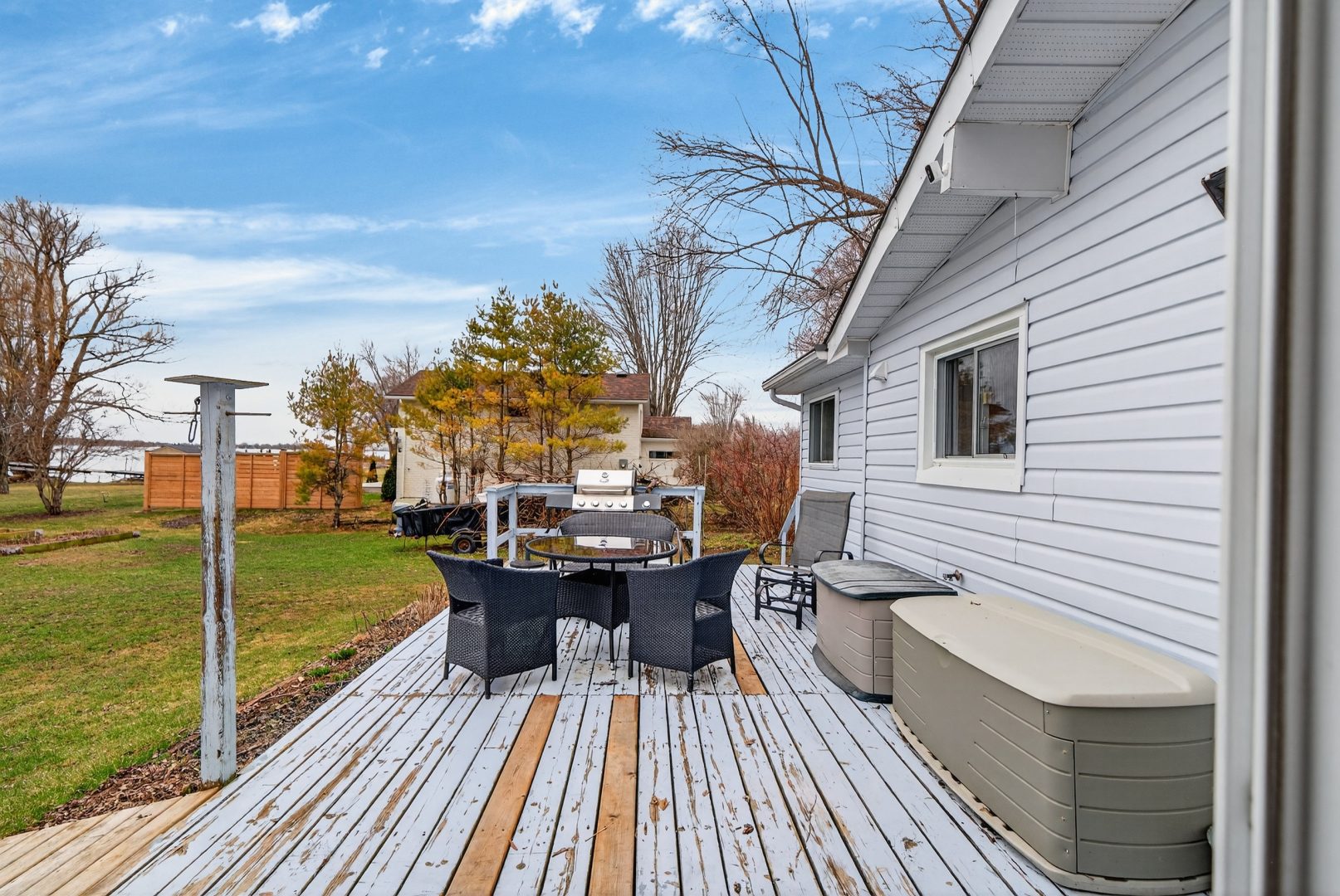 A black sitting around a patio table on a wood deck