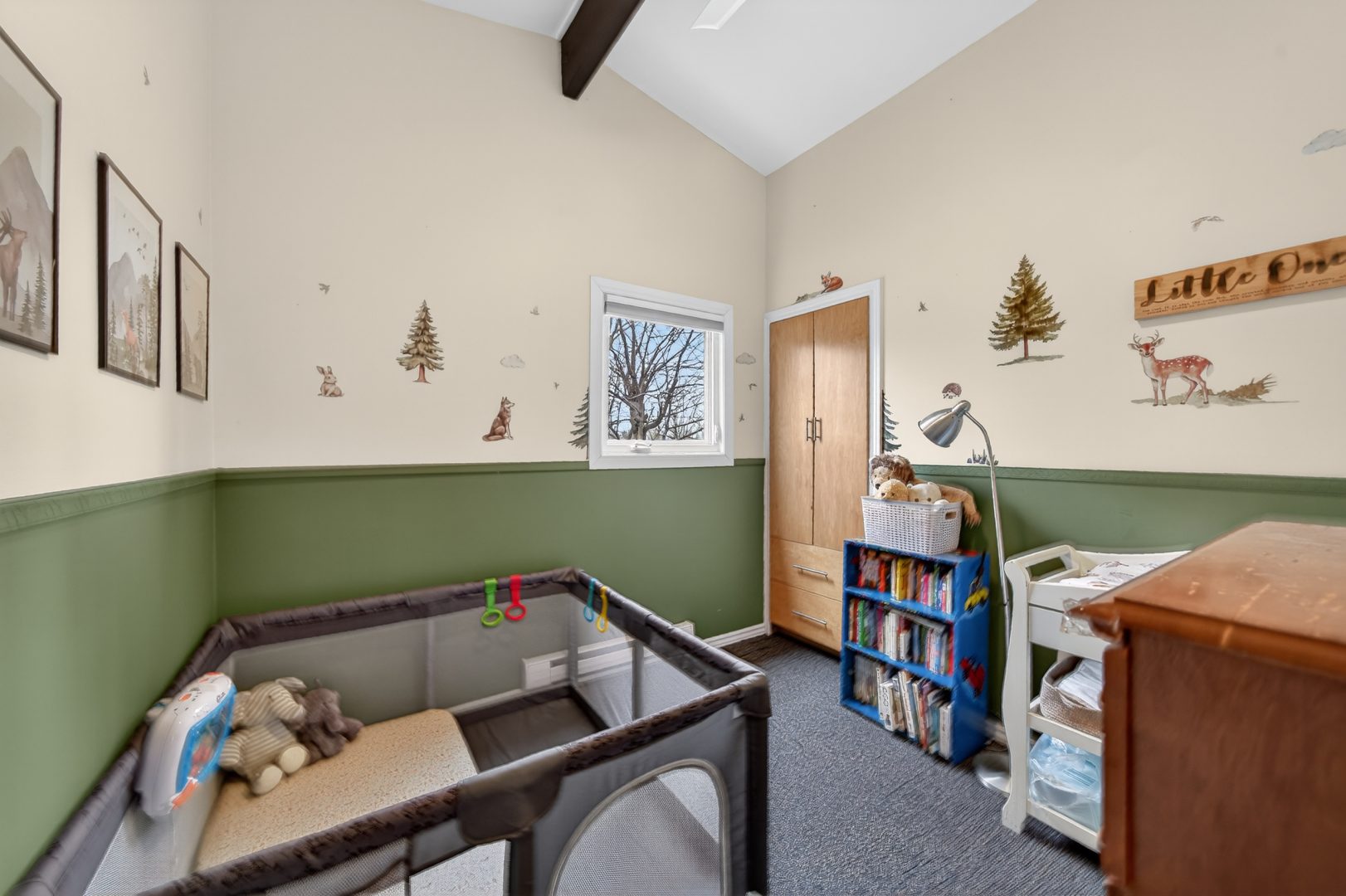 A kids room with the lower half of the wall painted green