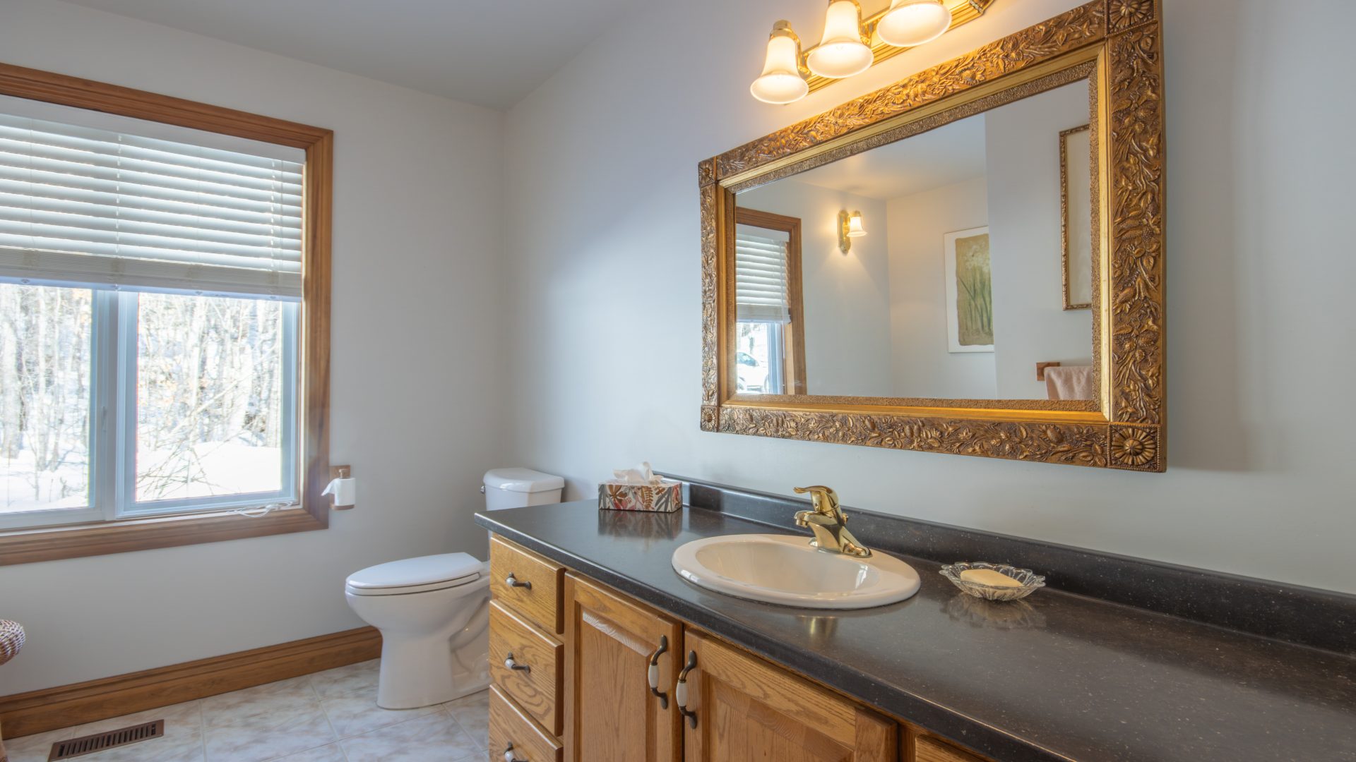 A long bathroom vanity with black countertops