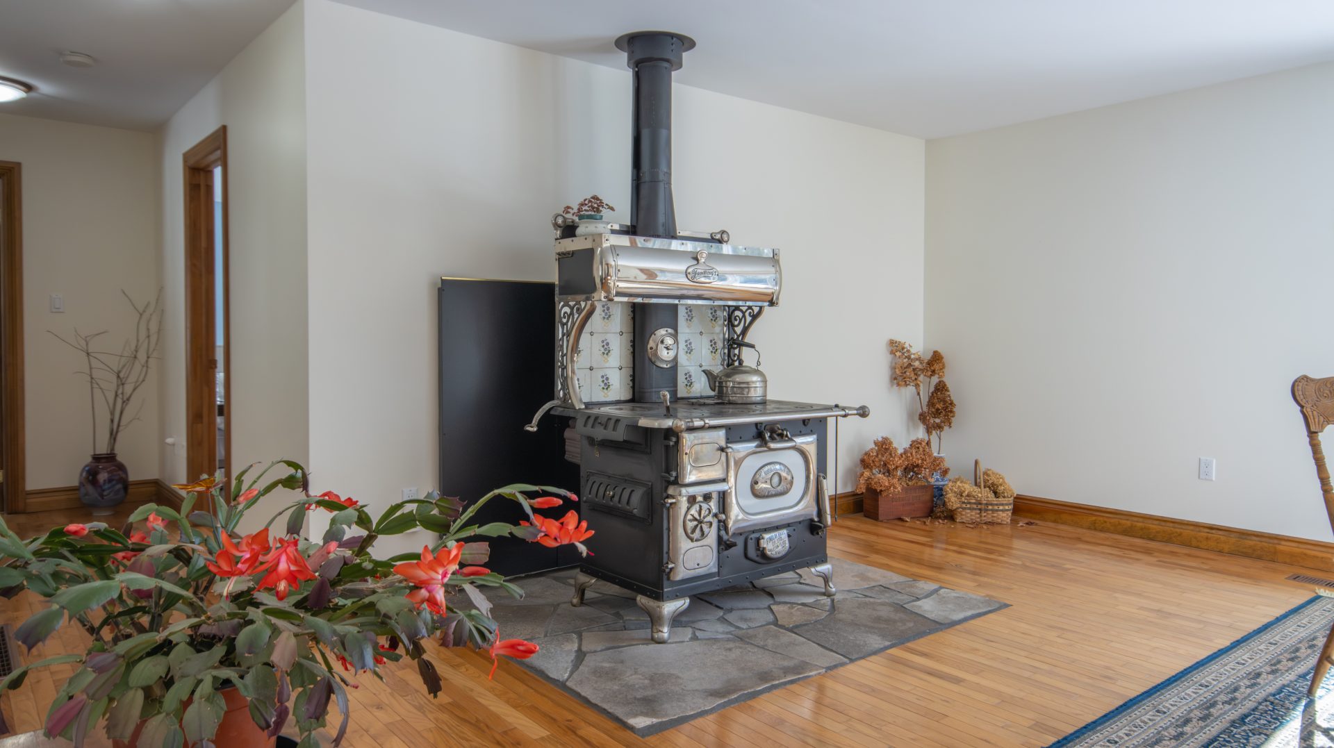 A black and silver woodstove on a stone square