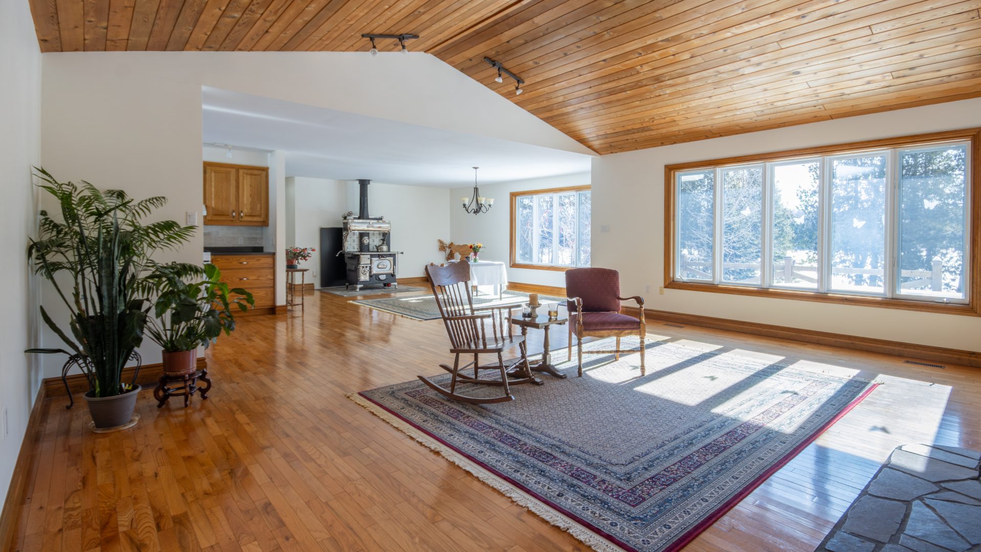 Chairs on a grey carpet in a spacious living room with wood cathedral ceilings