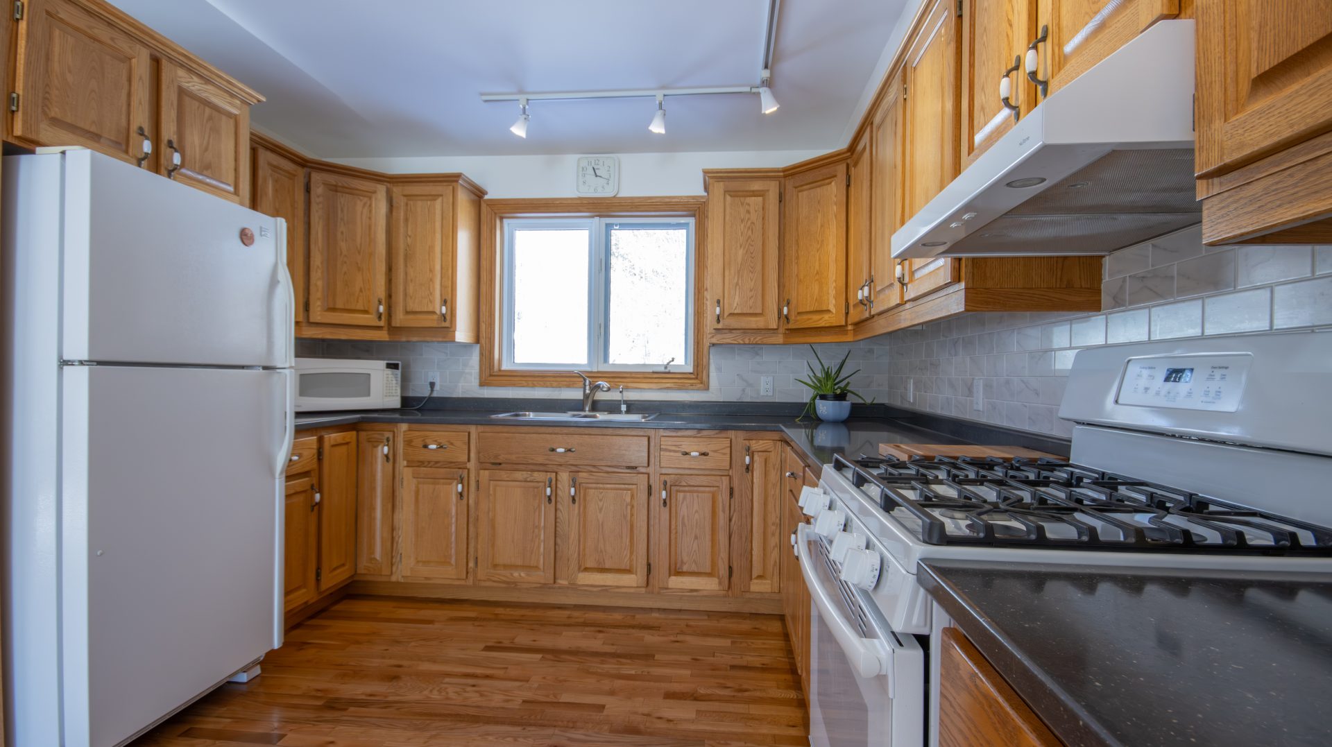 A wood kitchen with black countertops