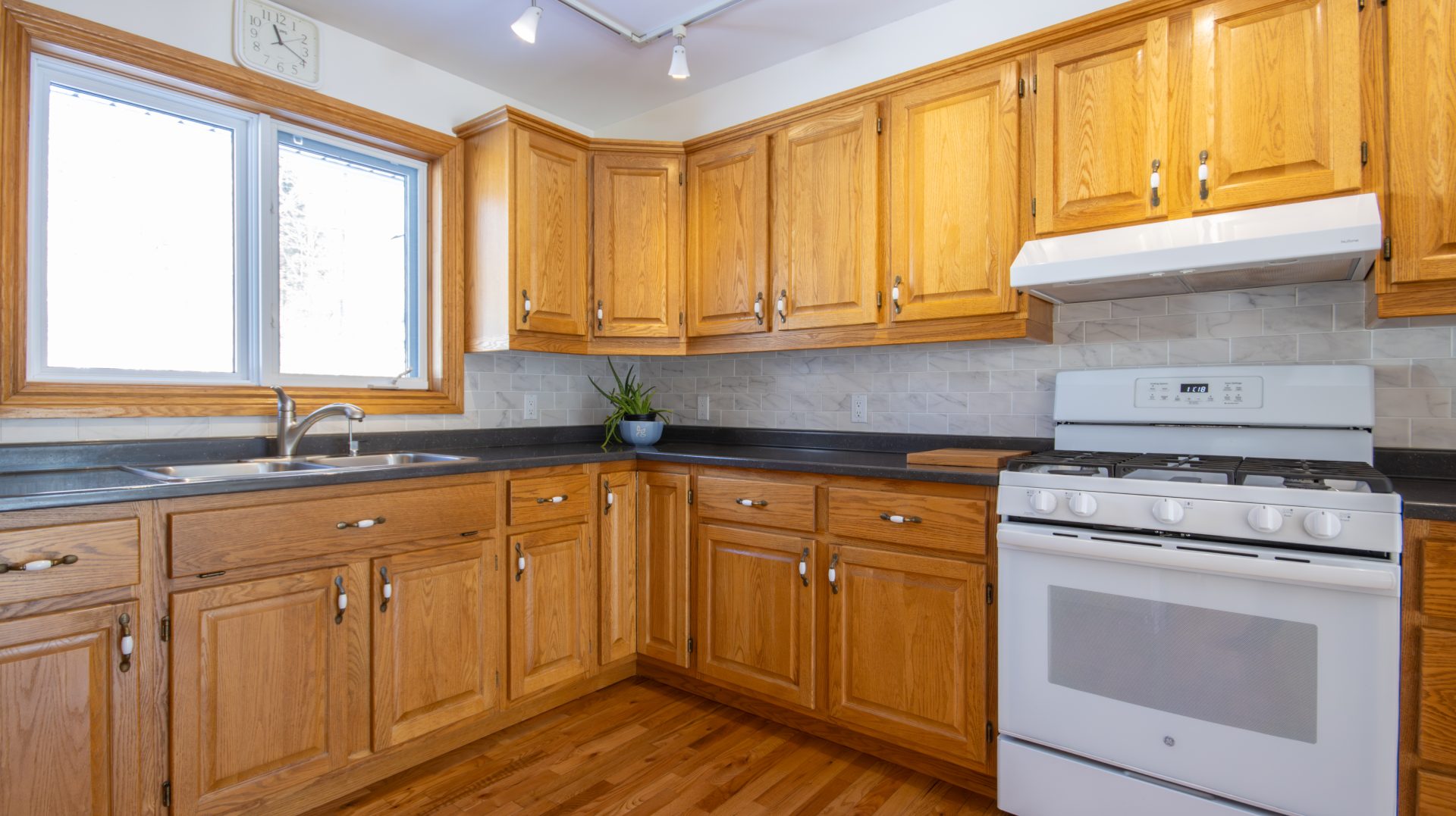 A small kitchen with wood cabinets and a white stove