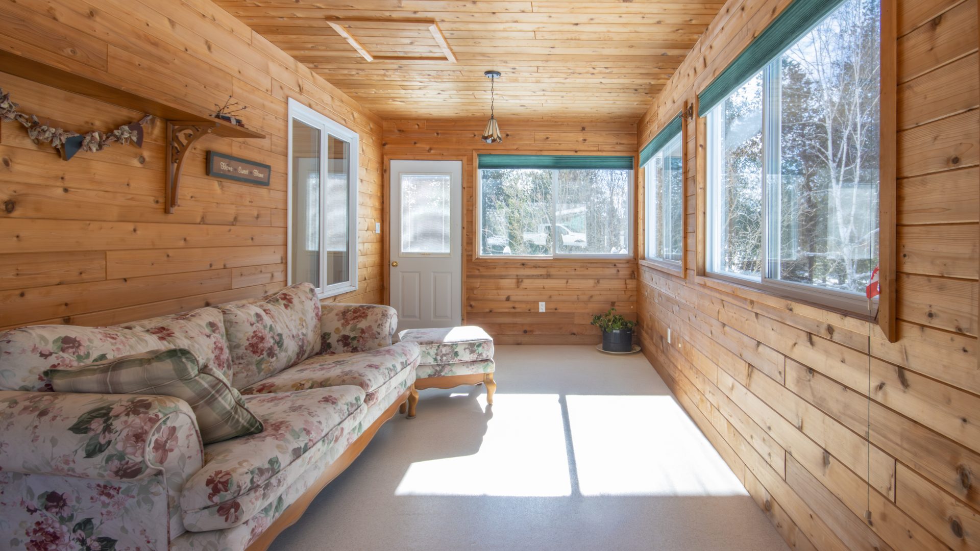 A floral couch in a wood sun room