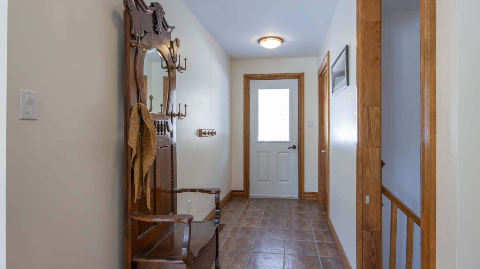 An entryway with white walls and a bench