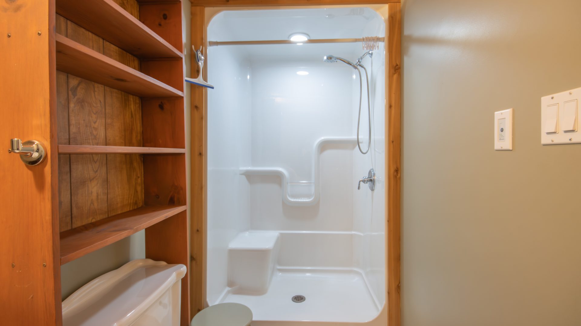 A white shower with wood trim