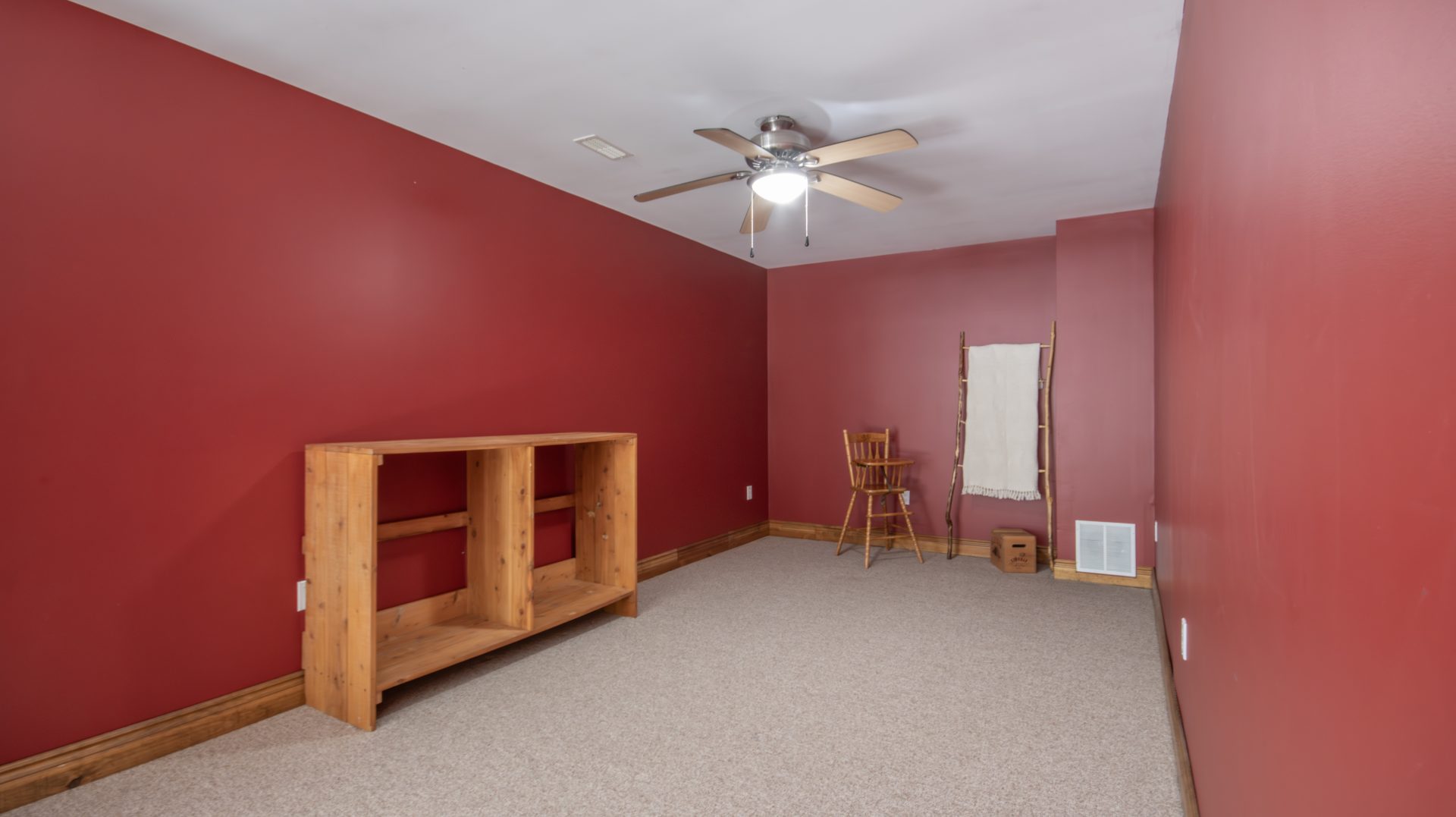 A burgundy bedroom with a wood shelf