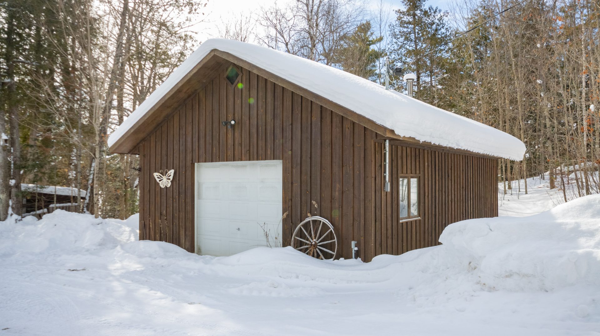 A dark wood garage surrounded by snow