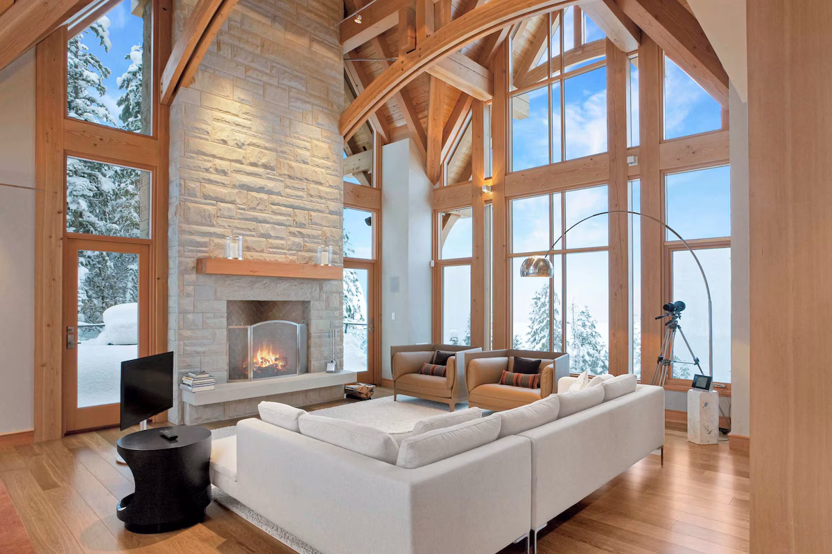Living room of the alpine chalet. The living room features a white couch and a white brick fireplace.