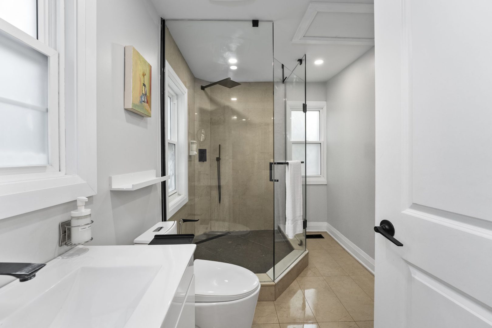 A white bathroom with a glass walk-in shower