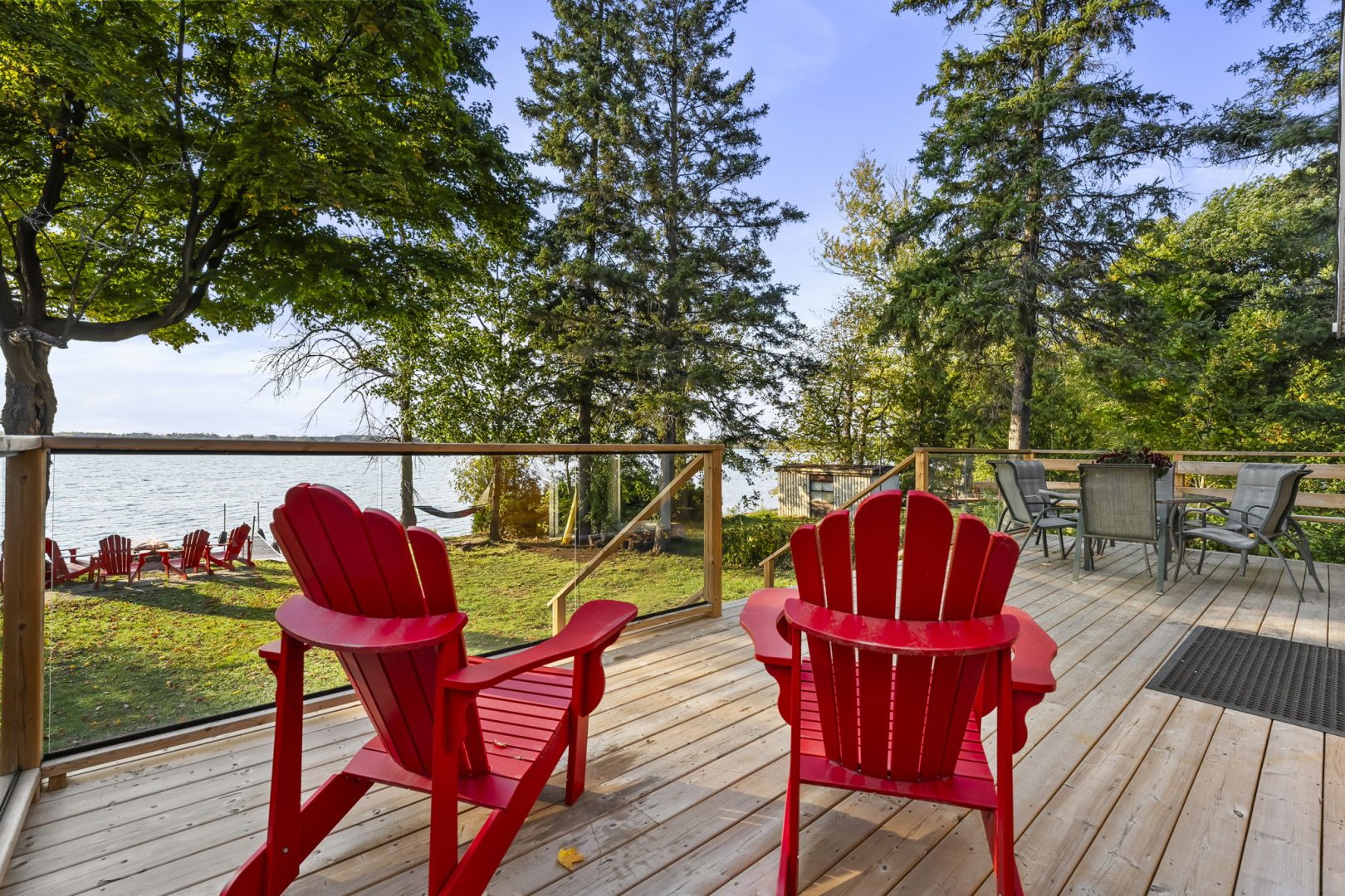 Two red Muskoka chairs on a deck