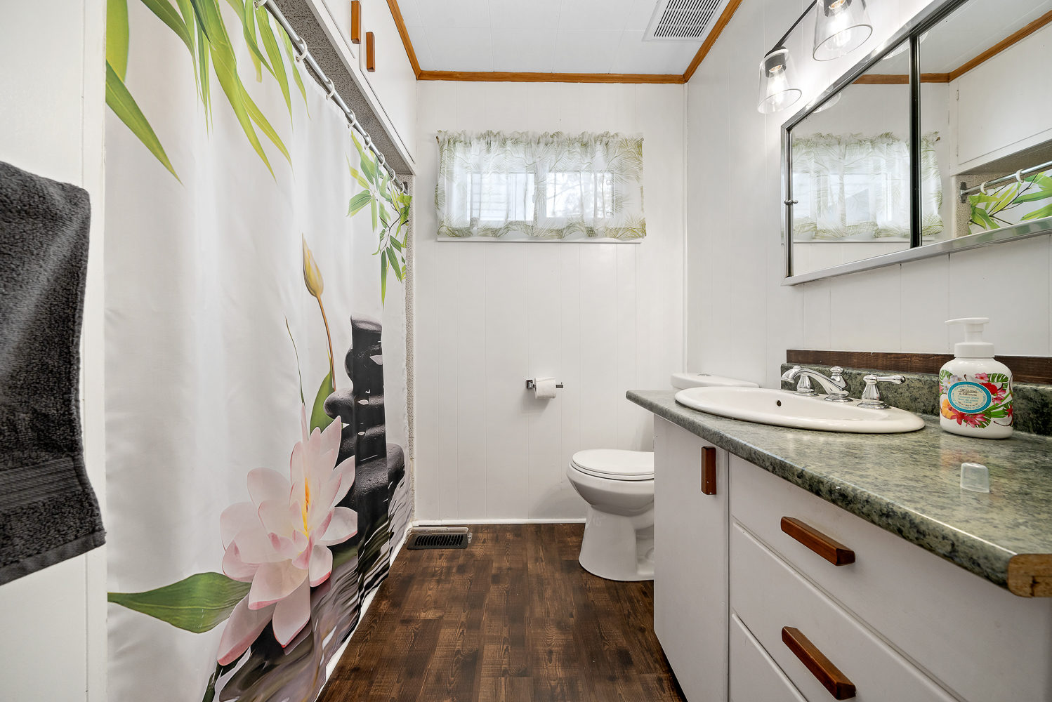 A white bathroom with a patterned shower curtain