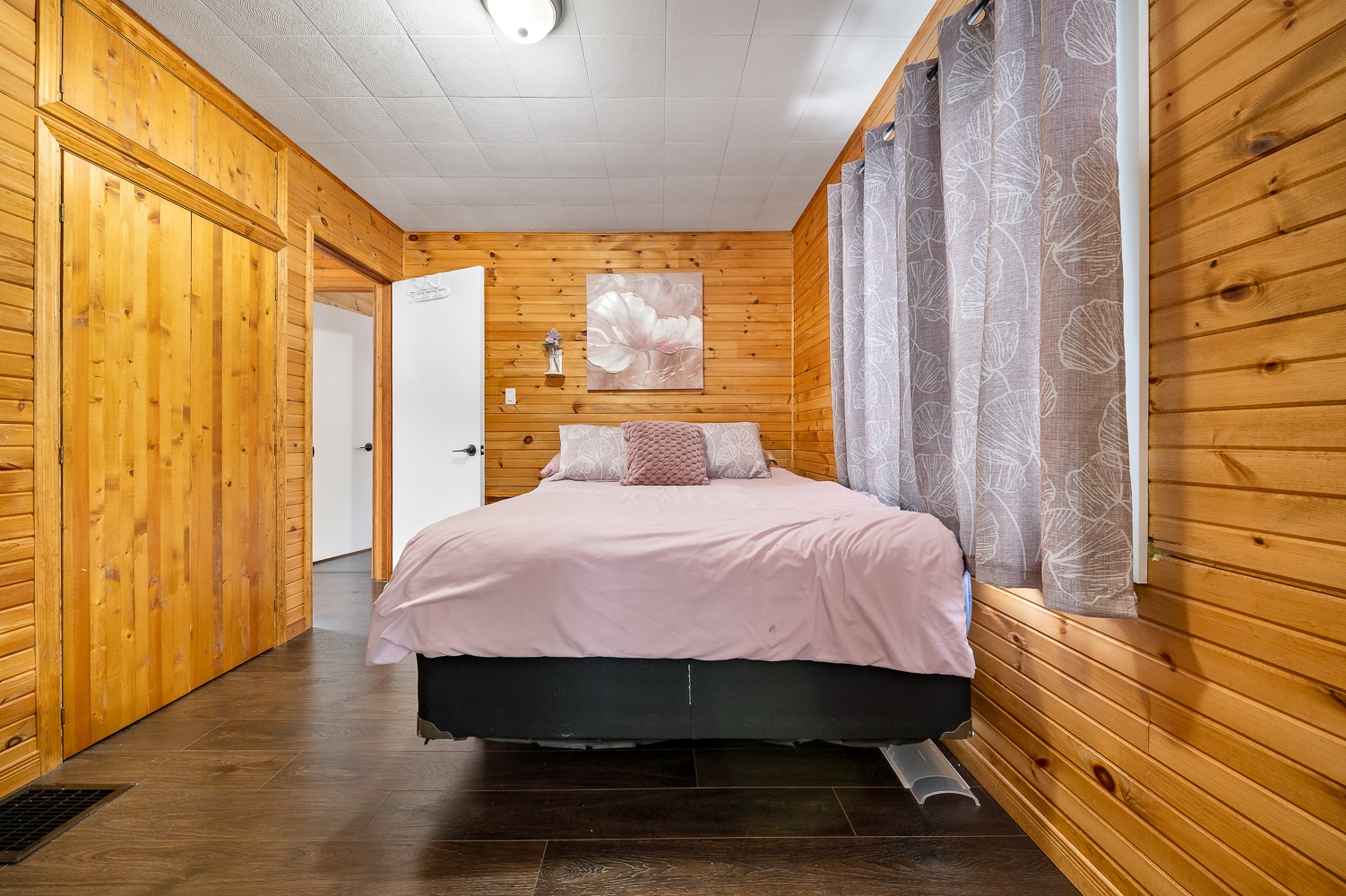 A light pink bed in a wood-clad bedroom