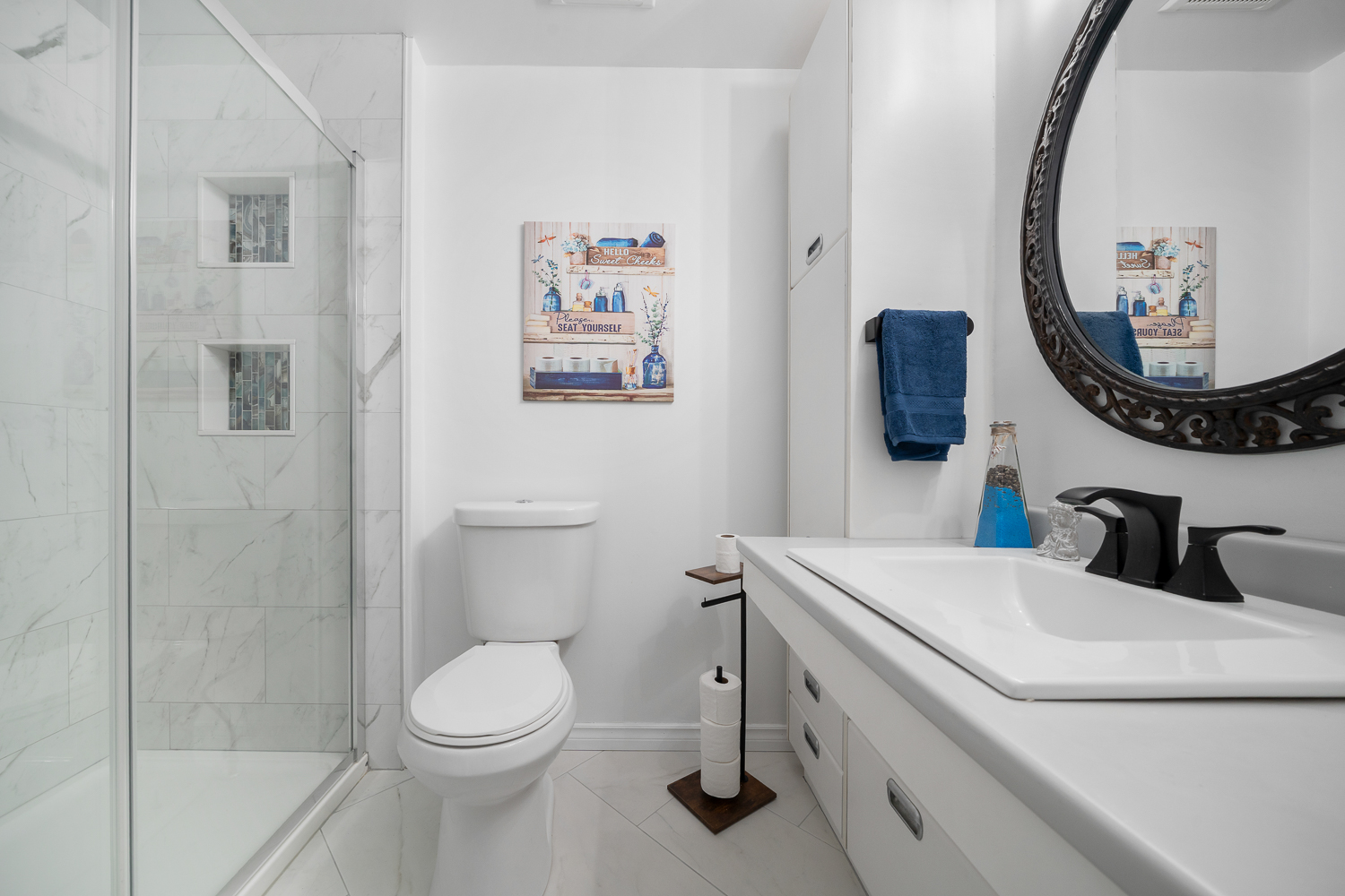 A white bathroom with a glass walk-in shower