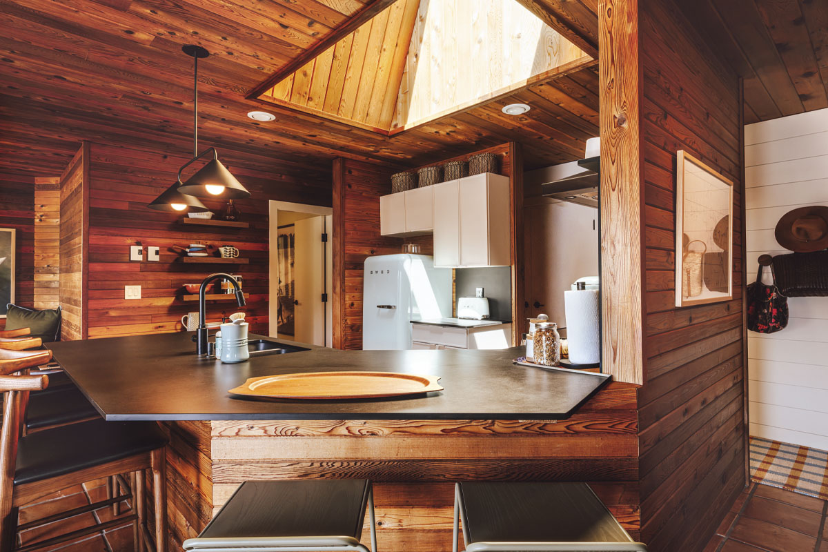 Kitchen with a black counter and wooden walls