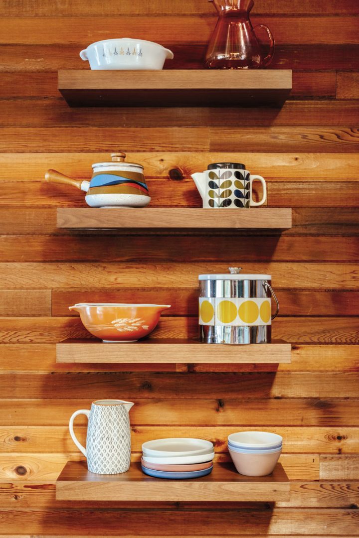 A set of thrifted dishes across four floating shelves
