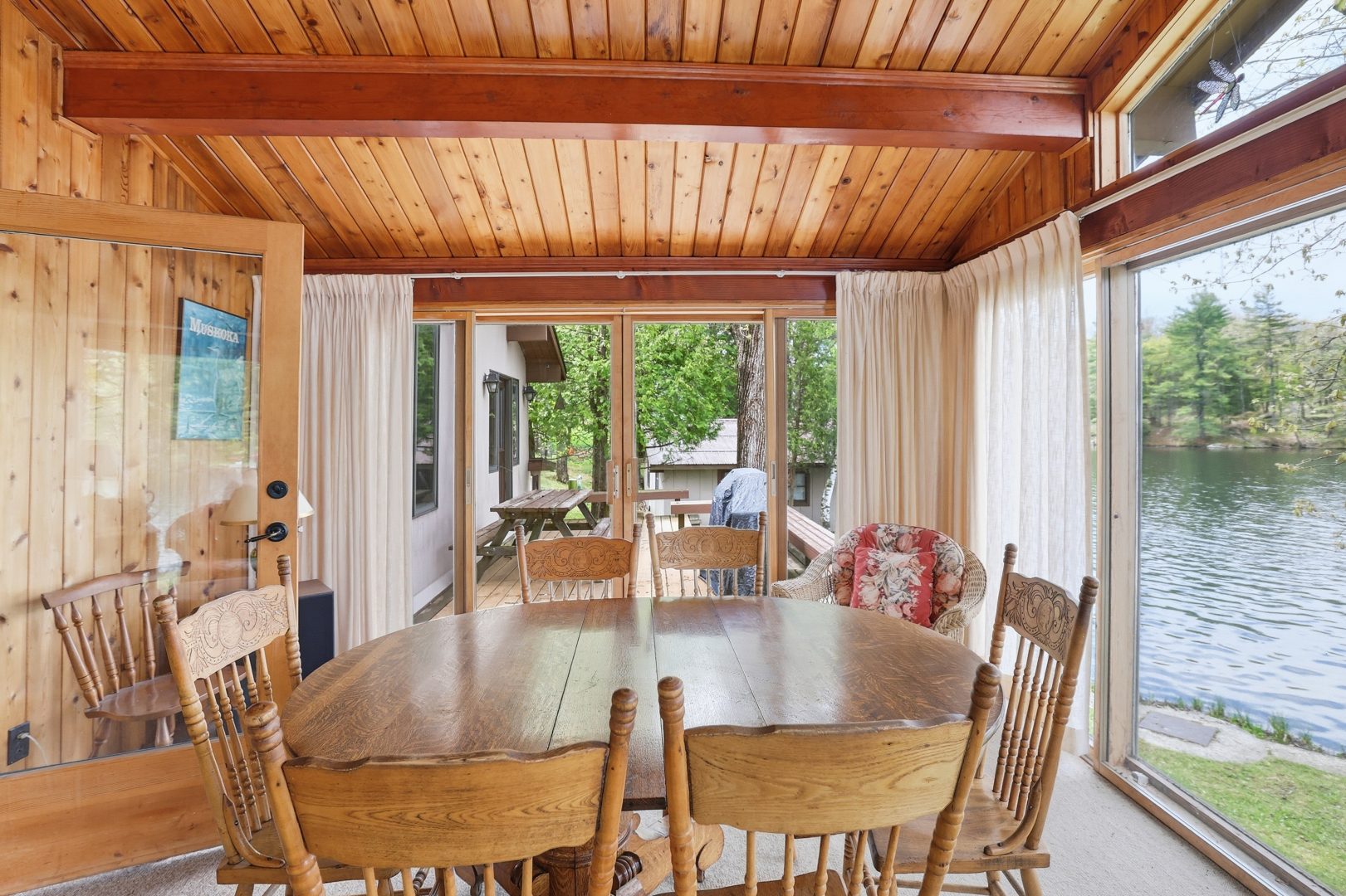 A wood dining area faces glass doors to a deck