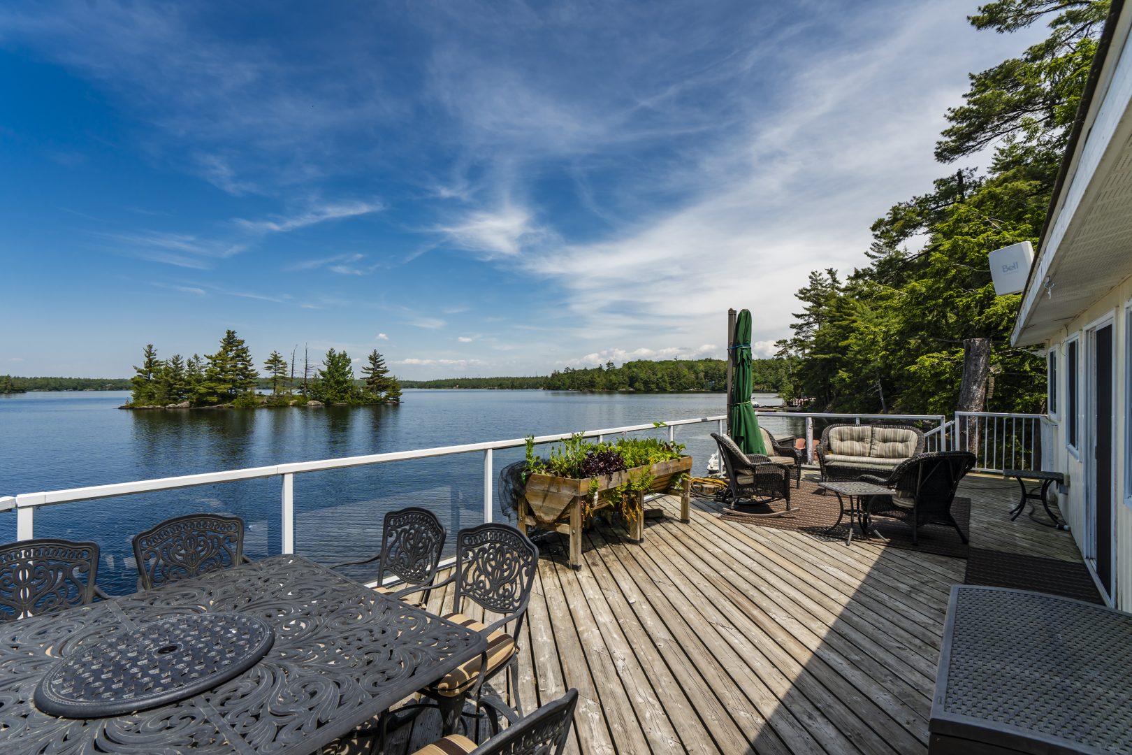 A wood deck with glass railings on the lake