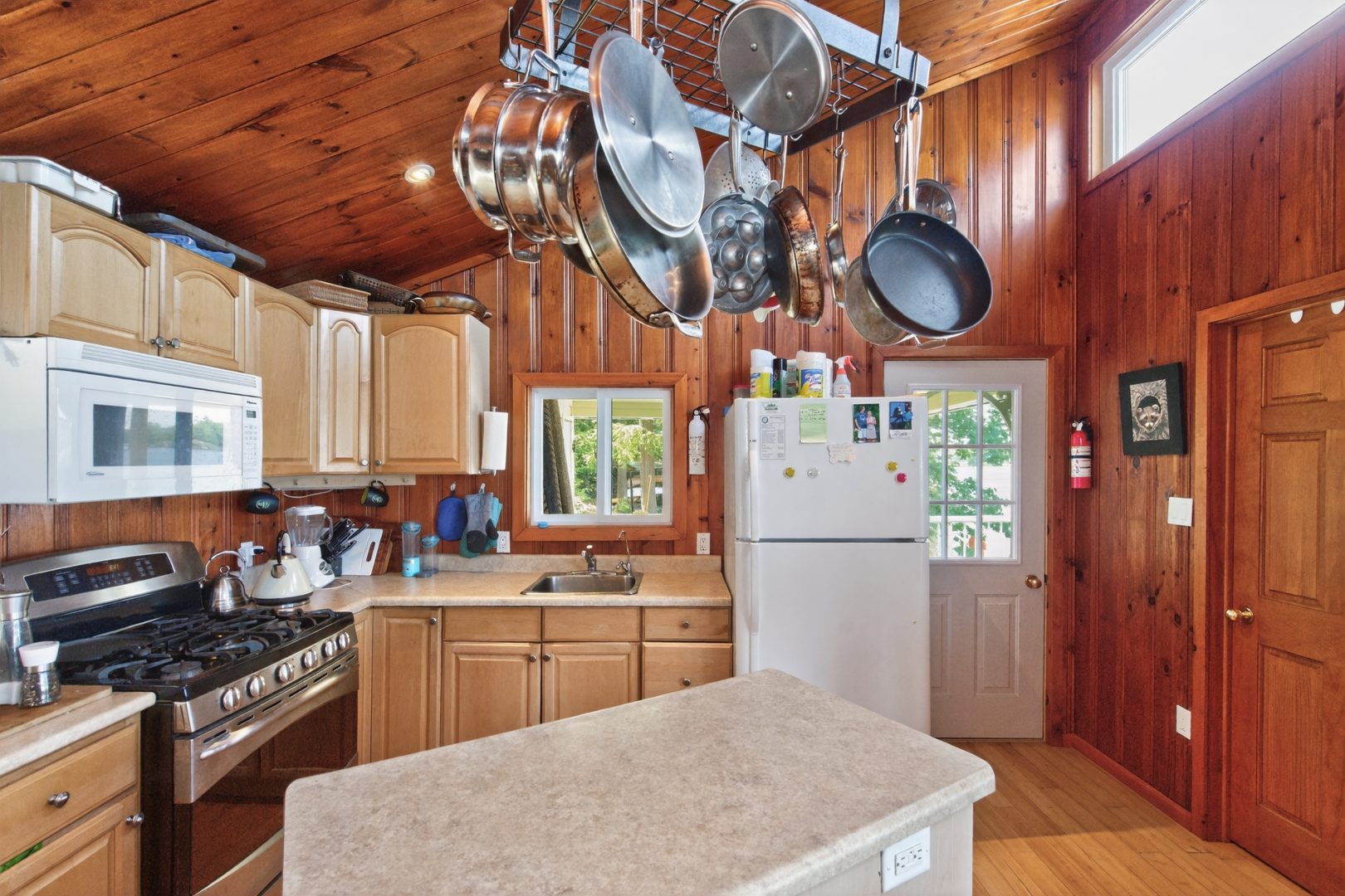 A light wood paneled kitchen with white appliances