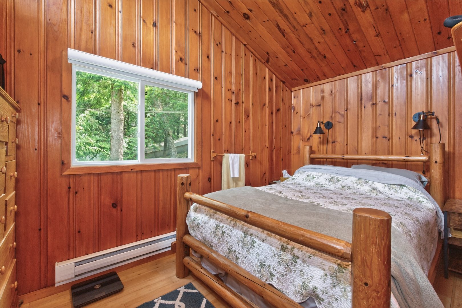 A wood bed frame with a white patterned bed
