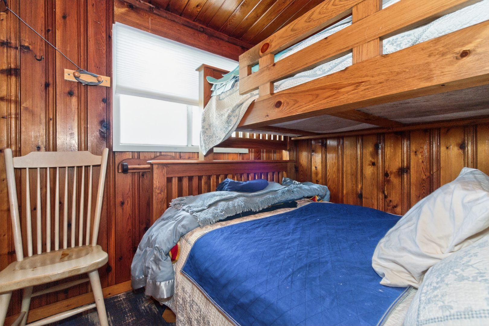 A wood bunk bed with blue covers