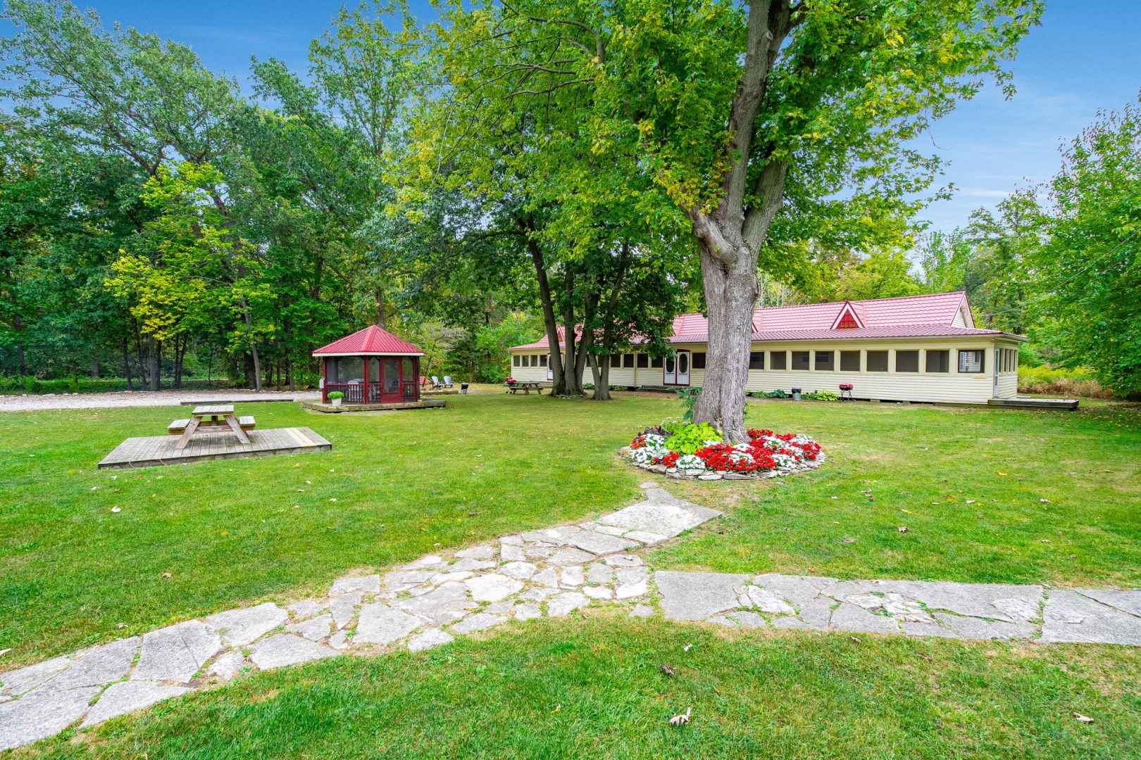 Grounds of a small hotel with a green front lawn and walking paths