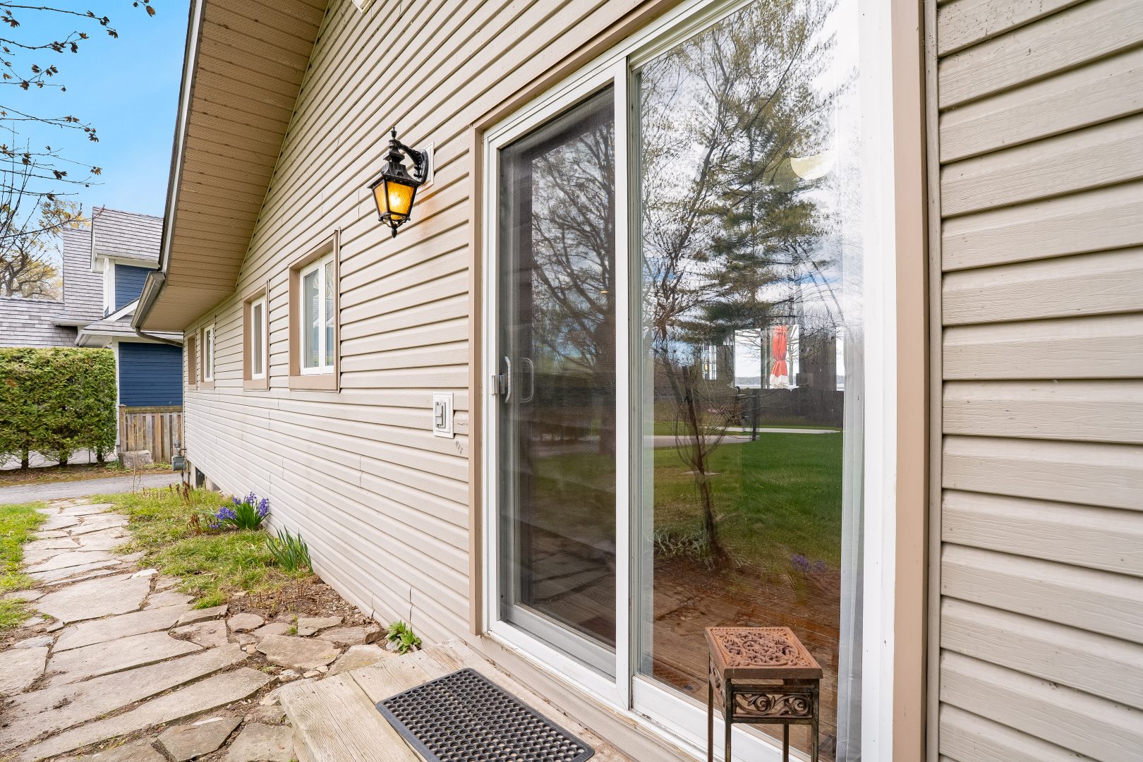 Sliding glass doors on a beige clapboard house