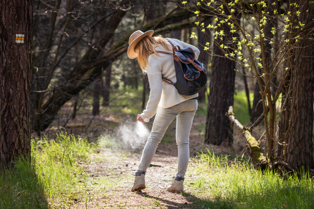 A woman applying bug spray