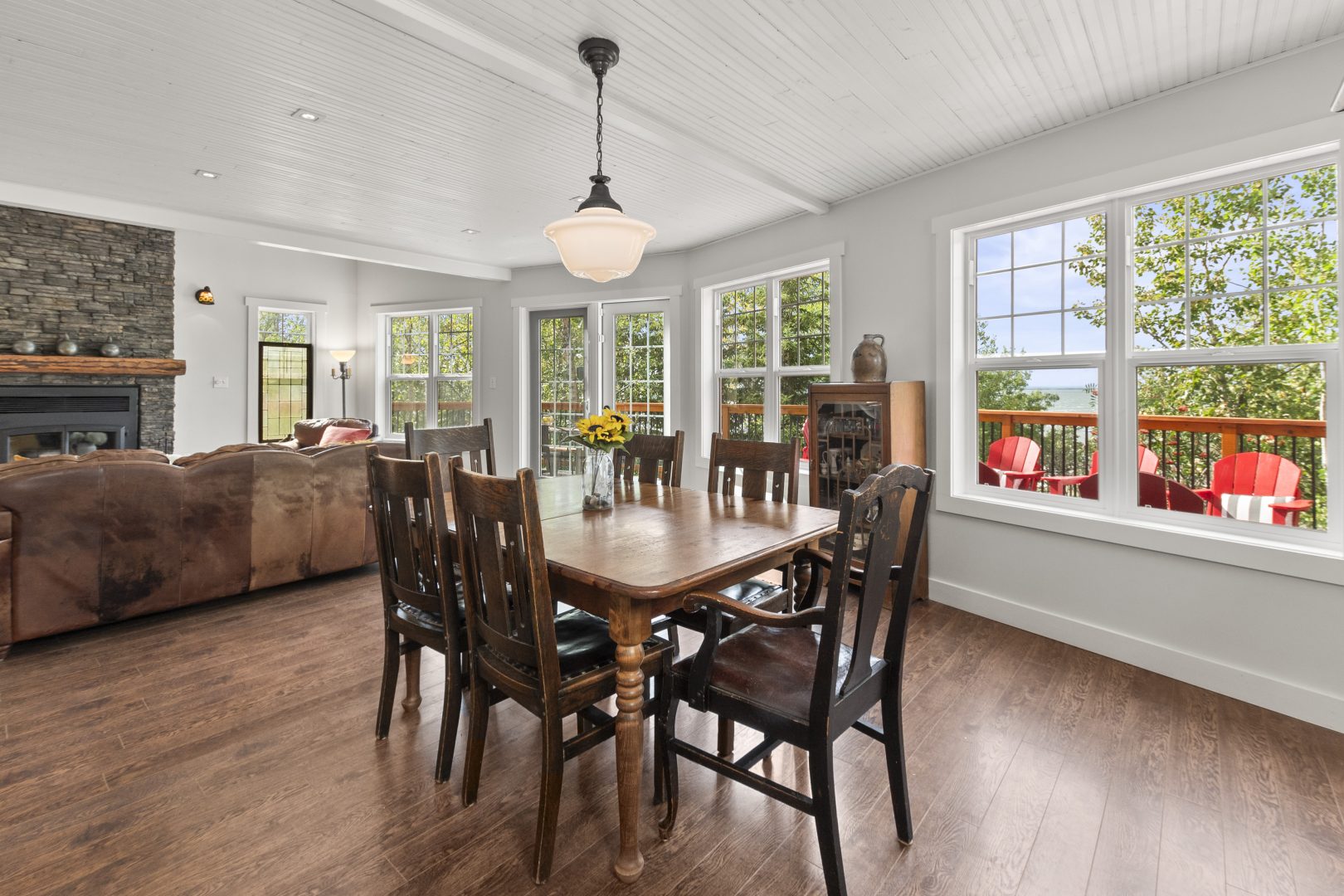 A wood dining table with dark chairs in a white dining area