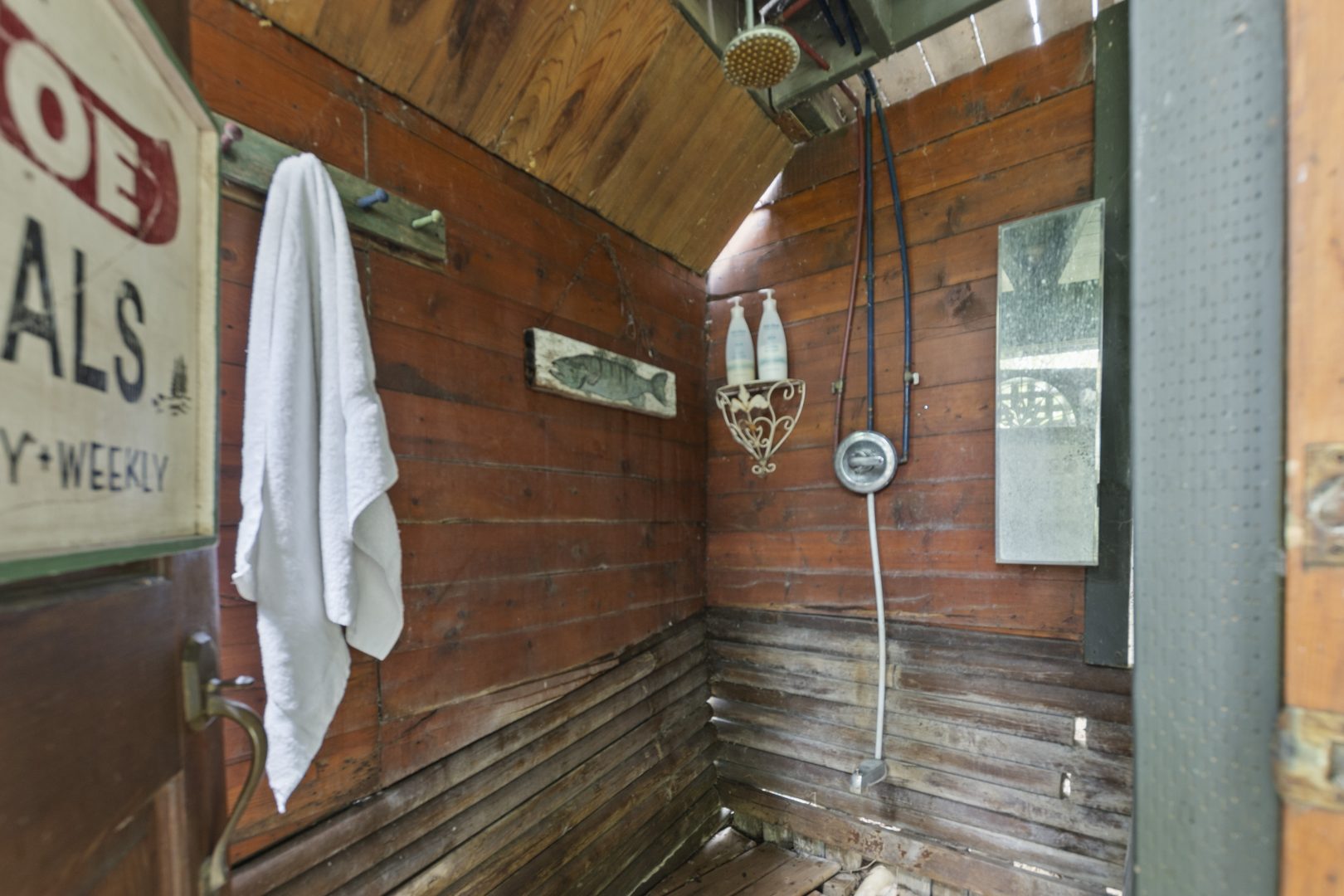 An outdoor shower in a wood-clad room
