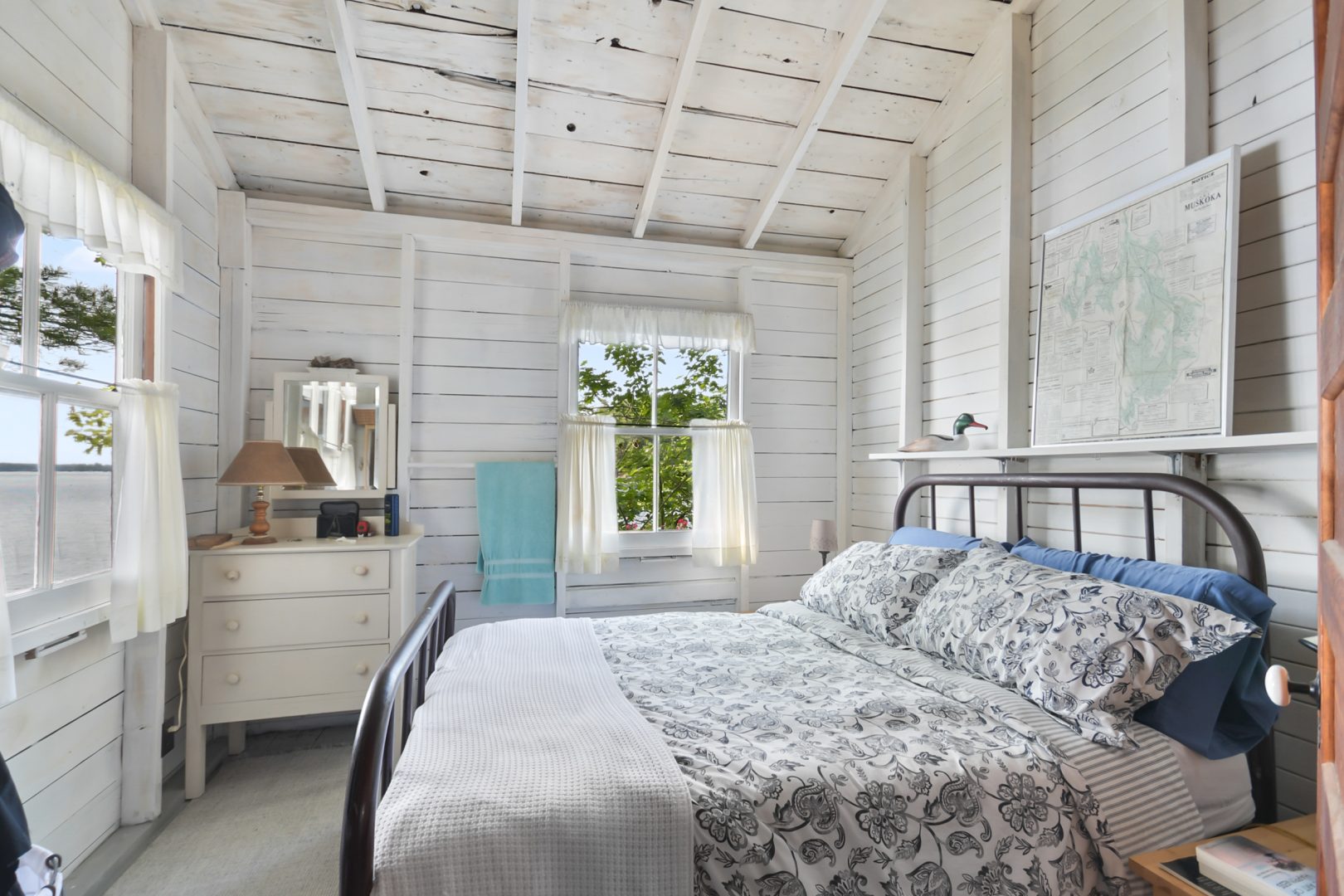 A blue-and-white bed in a white bedroom