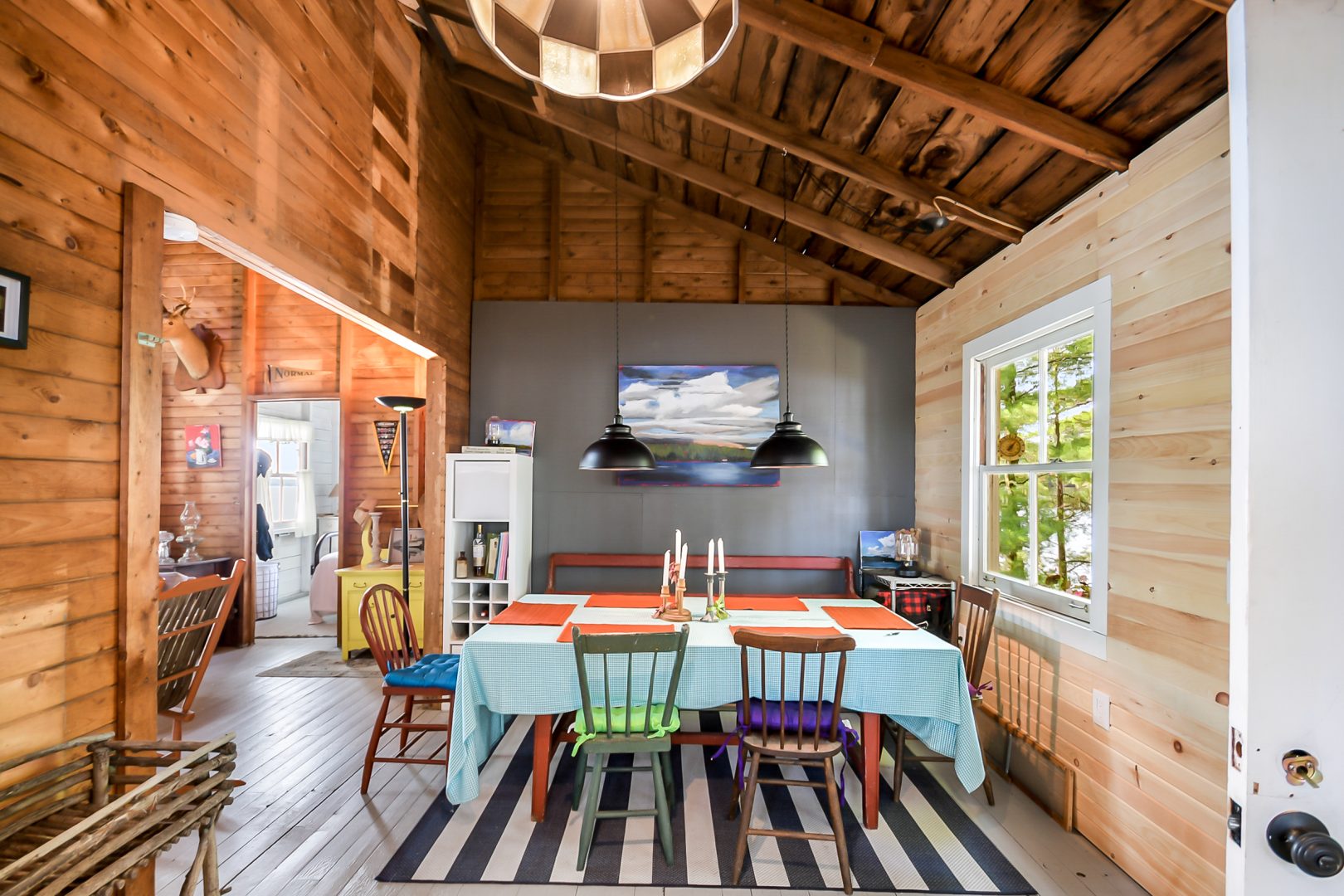 A dining table with a colourful tablecloth in a wood-paneled dining room