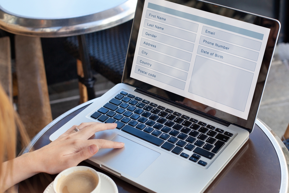 Close up of a woman filling out a form on the computer