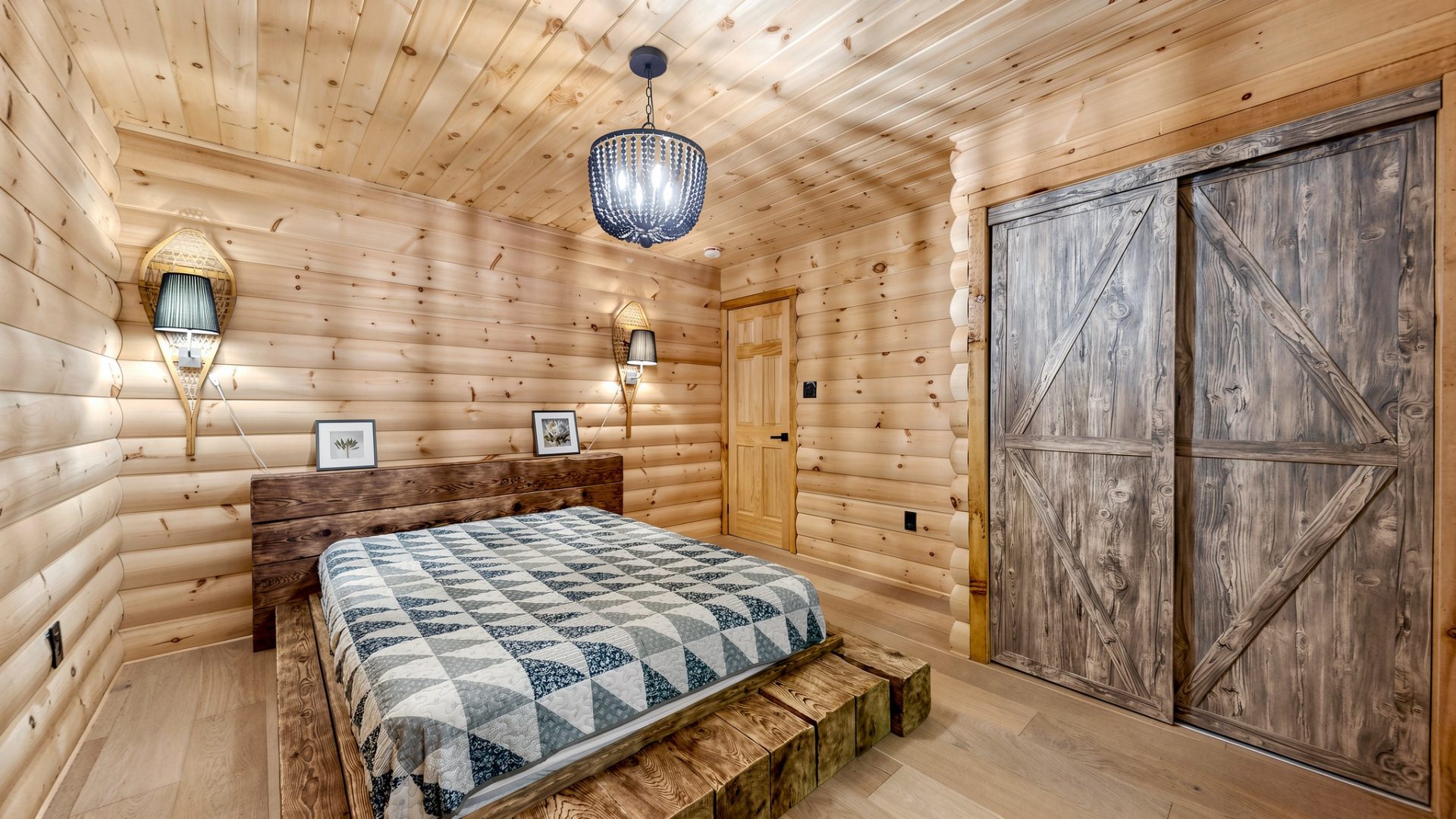 A bed with a geometric patterned bedspread in a wood room