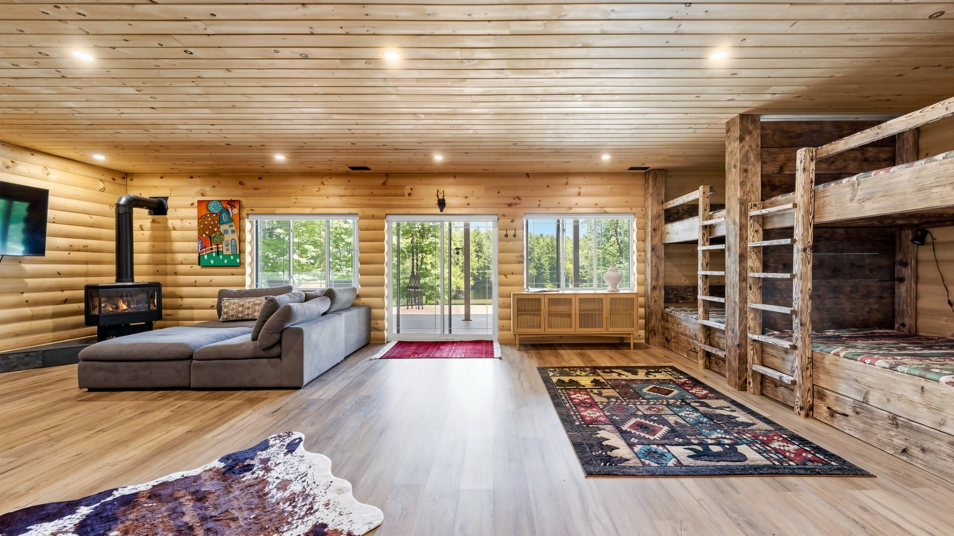 A grey couch next to sliding glass doors and an oversized patterned rug