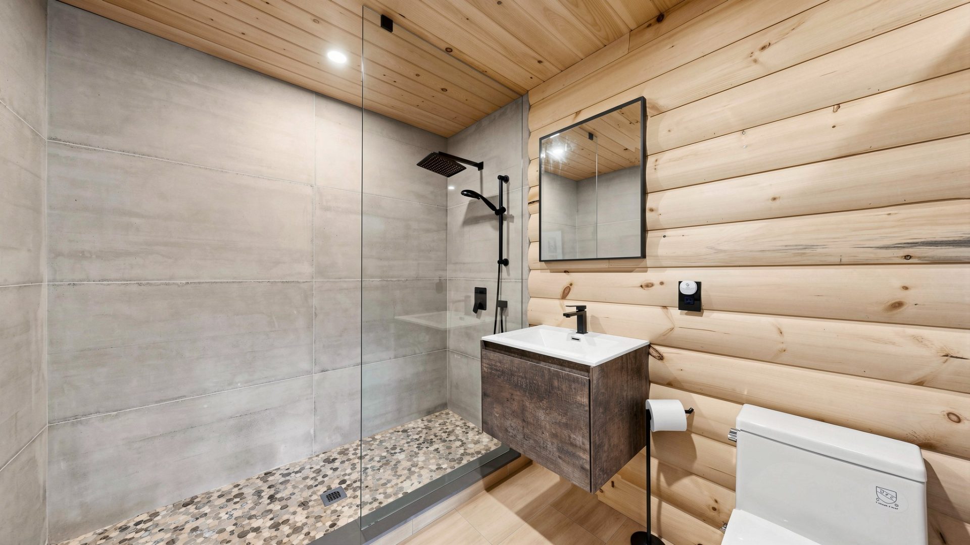 A walk-in shower next to a wood vanity