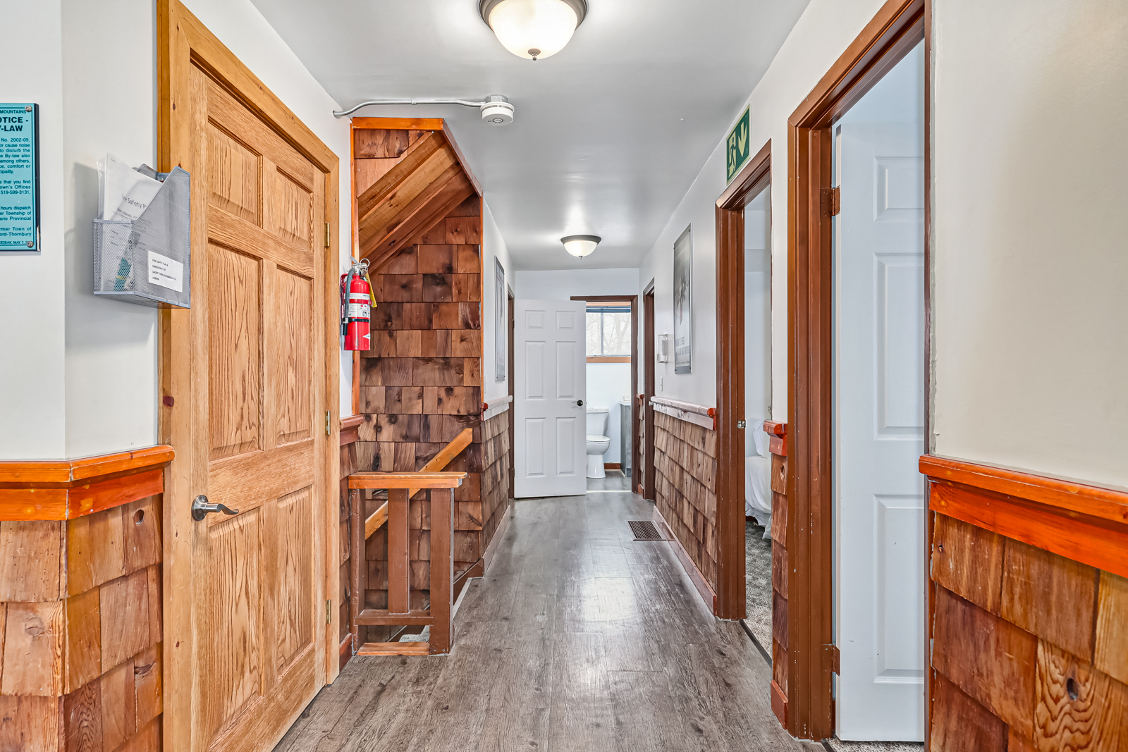 A narrow hallway with wood-framed doorways