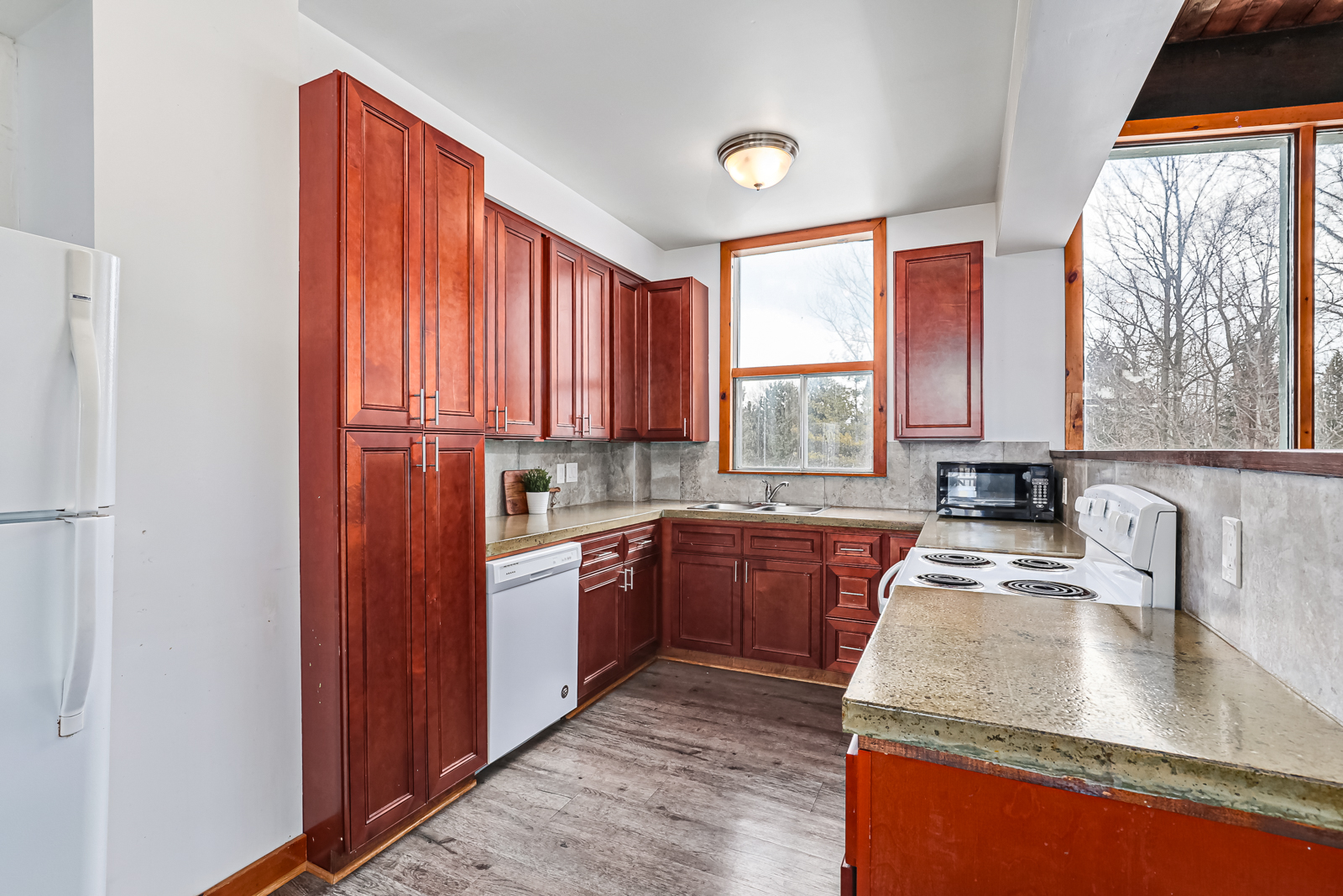 A red-wood kitchen with white appliances