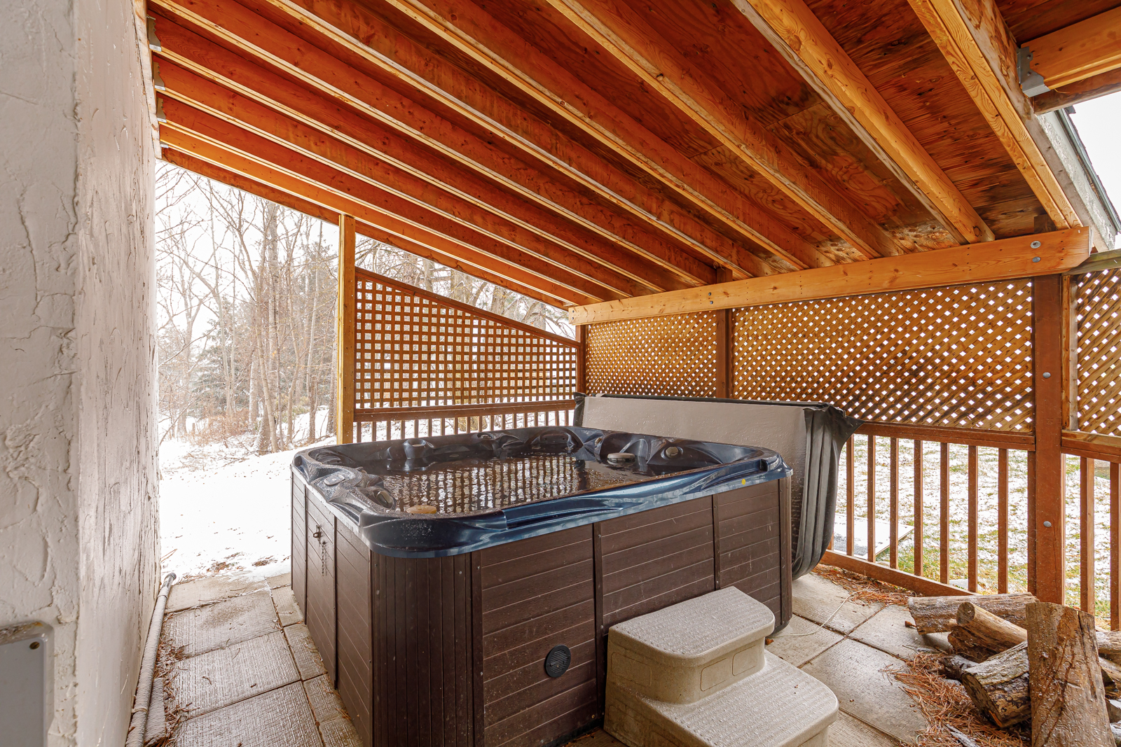 A hot tub under a wood awning