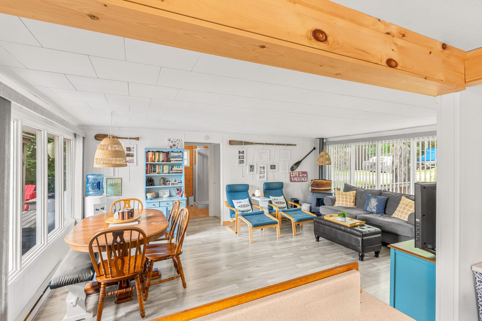 A spacious living area with a round wood table and a grey couch
