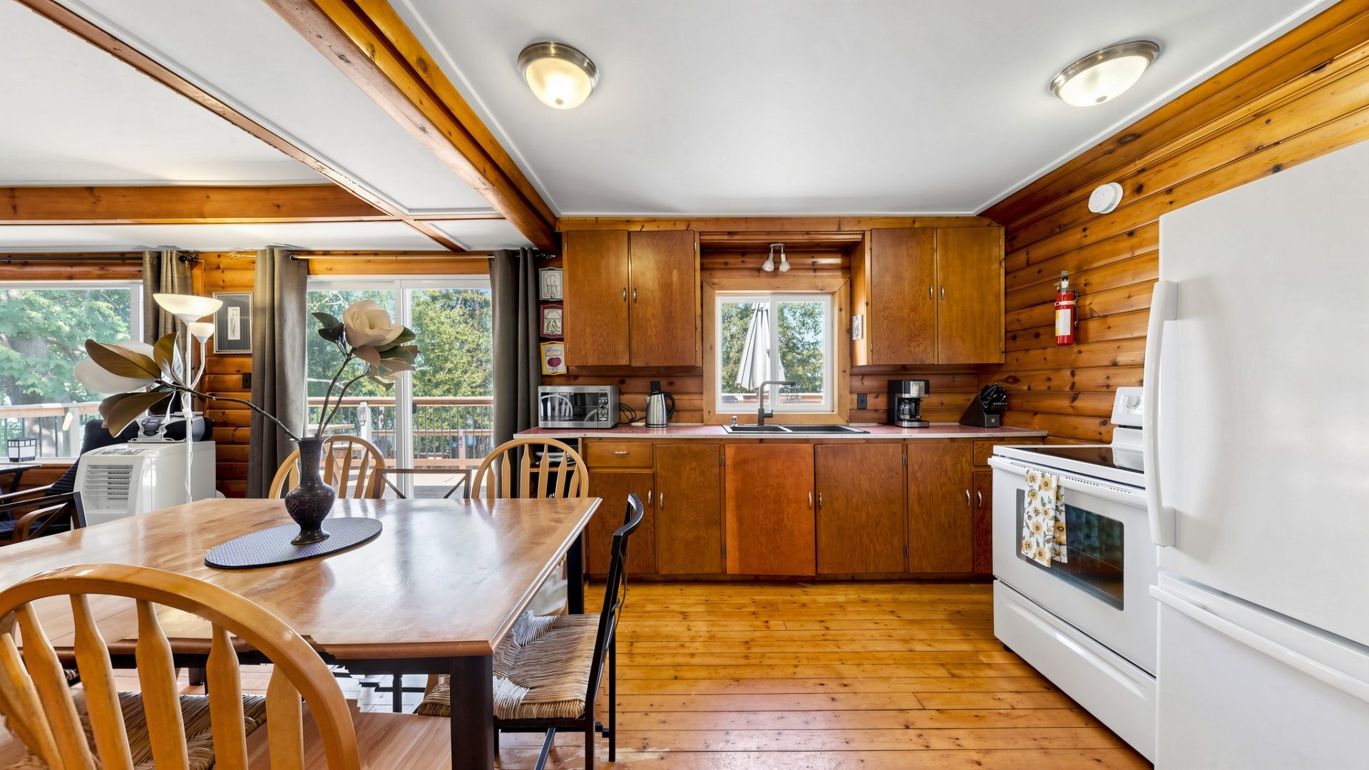 An open-concept kitchen area with wood cupboards and white appliances