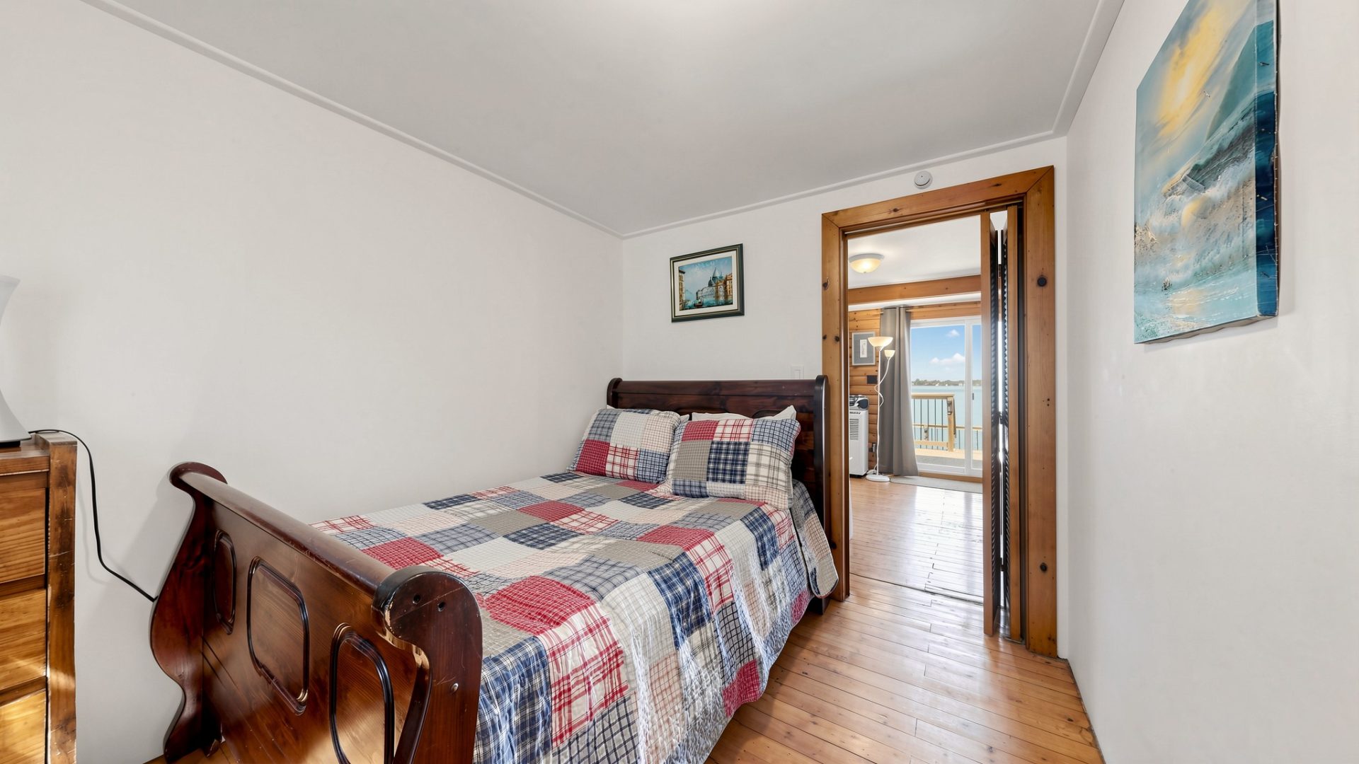 A twin-sized bed with a plaid bedspread in a white bedroom