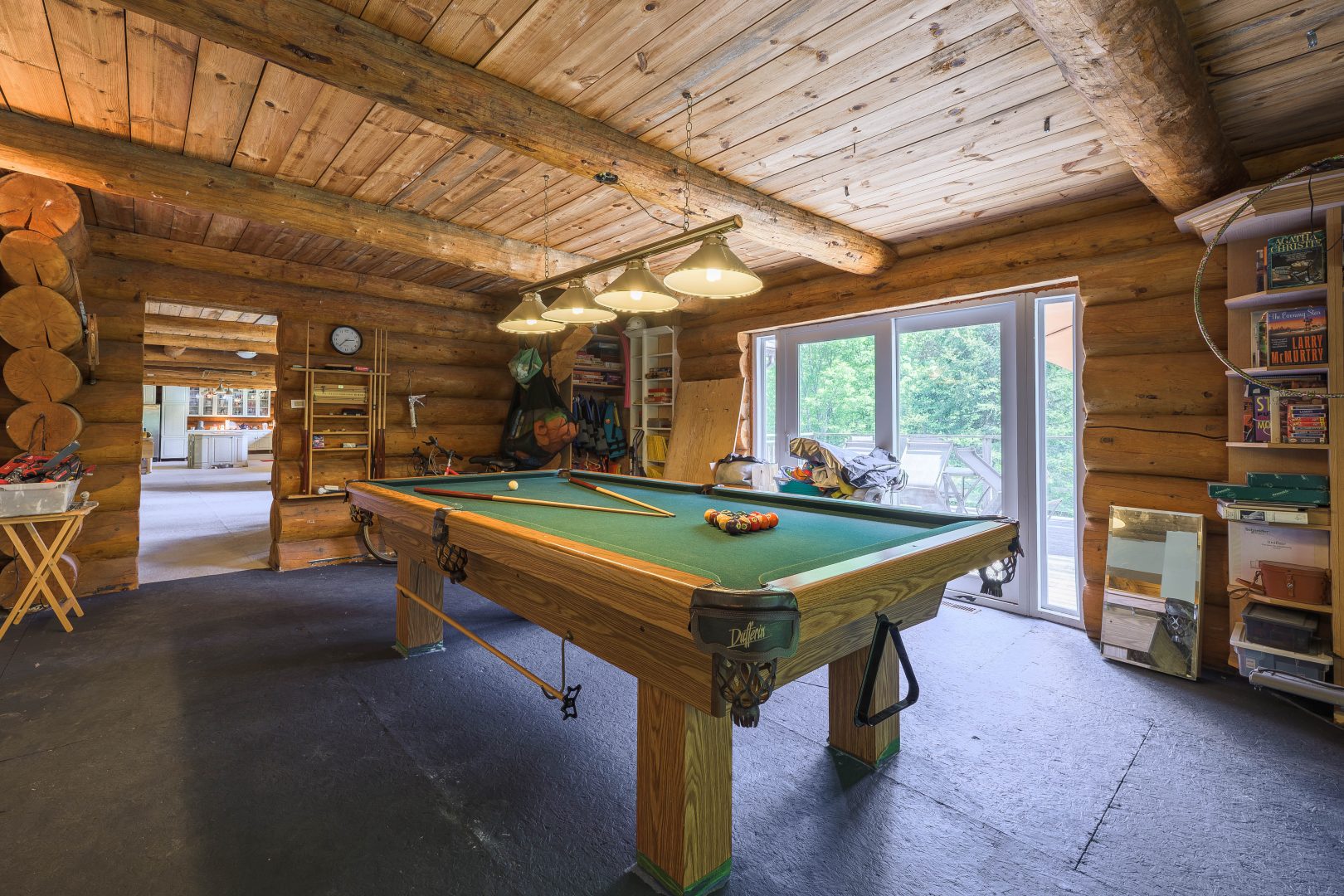 A pool table with a green felt top in a wood room