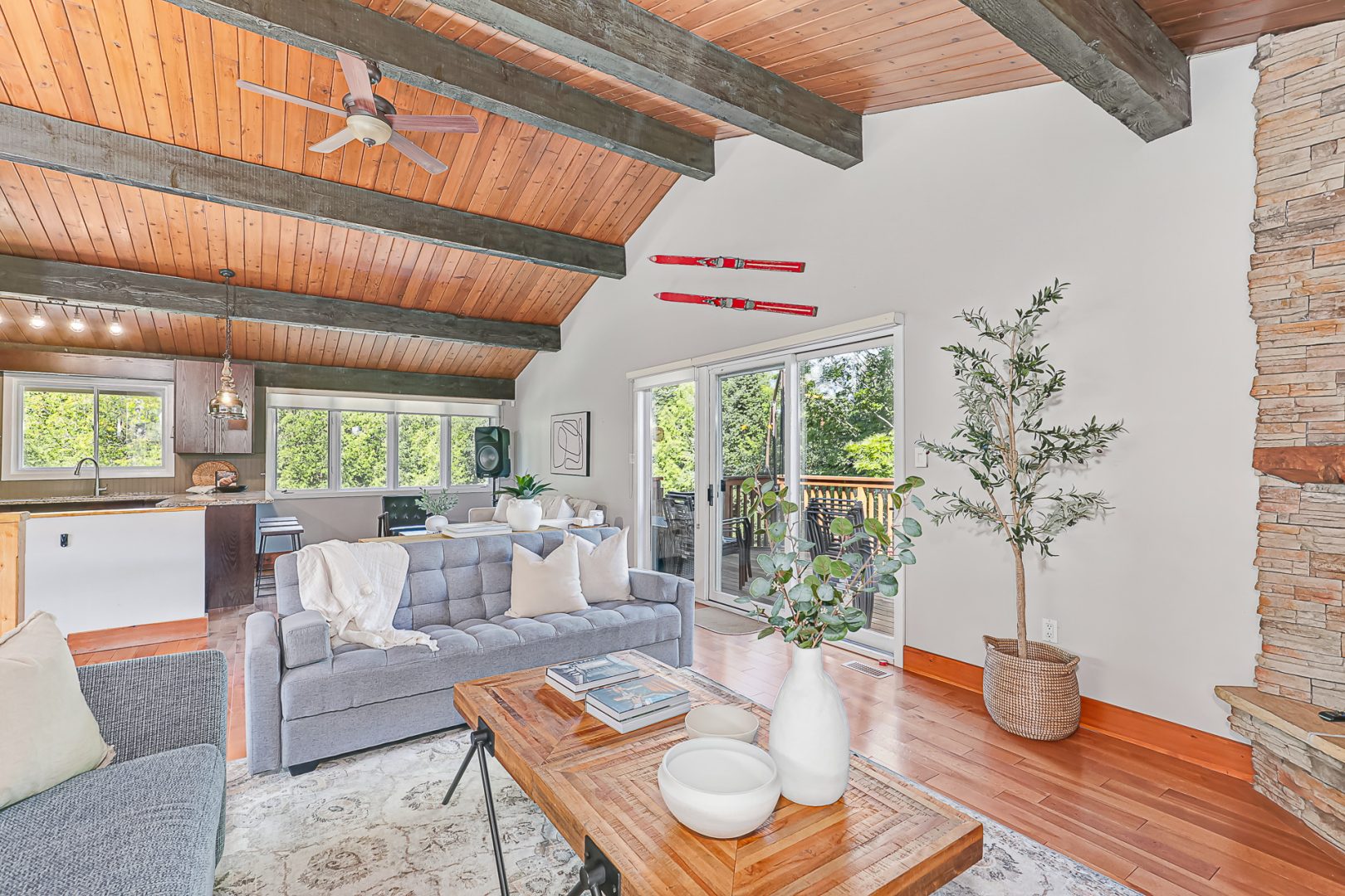 A light grey couch faces a wood coffee table in a spacious living room