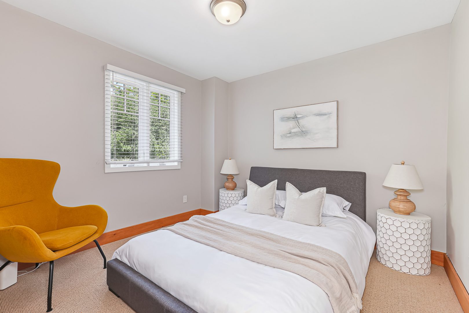A white bed on a grey bedframe